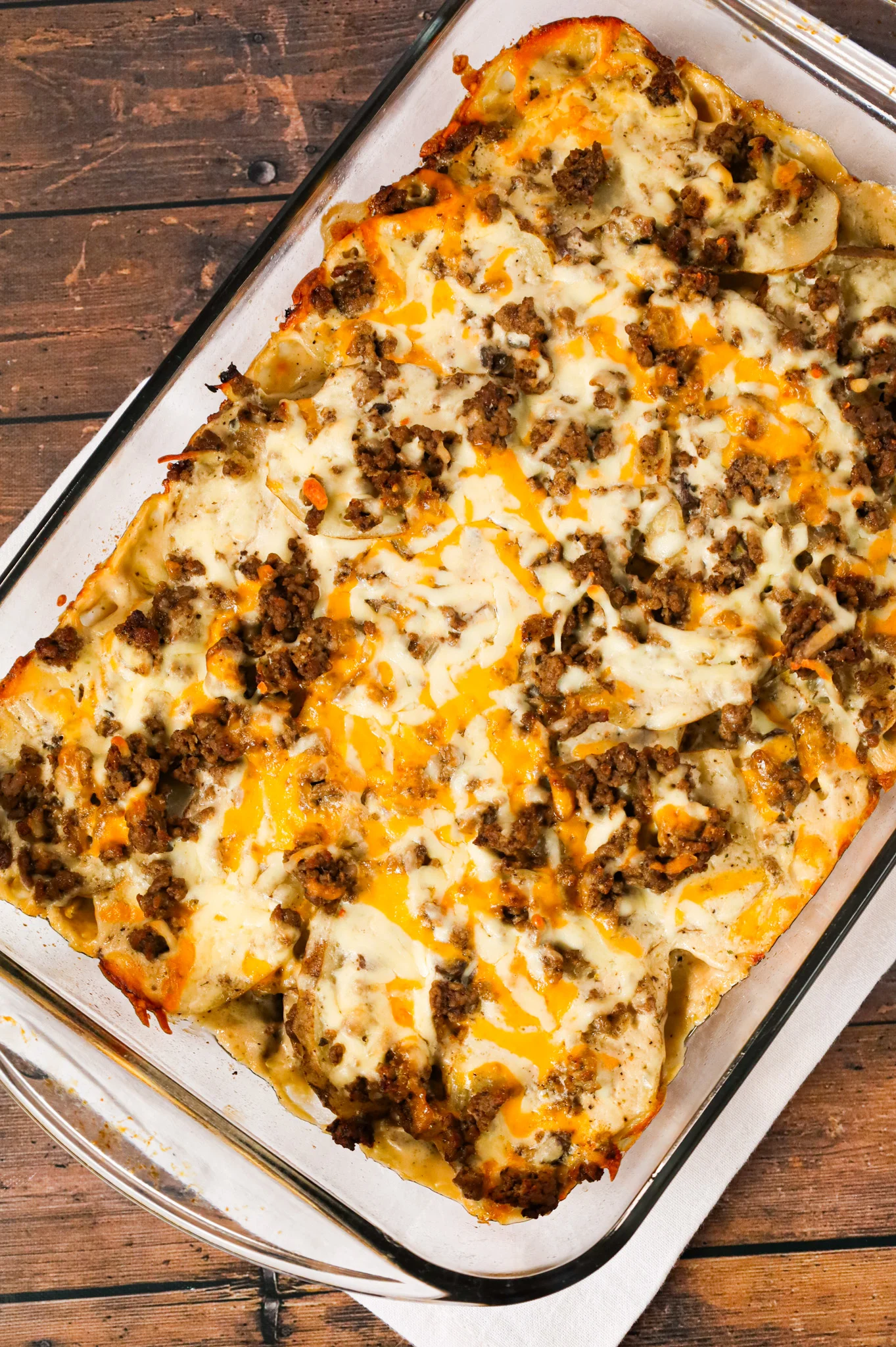 Hamburger Potato Casserole is a hearty dinner recipe with layers of sliced potatoes loaded with crumbled ground beef and shredded cheese all cooked in a cream of mushroom soup and sour cream mixture.