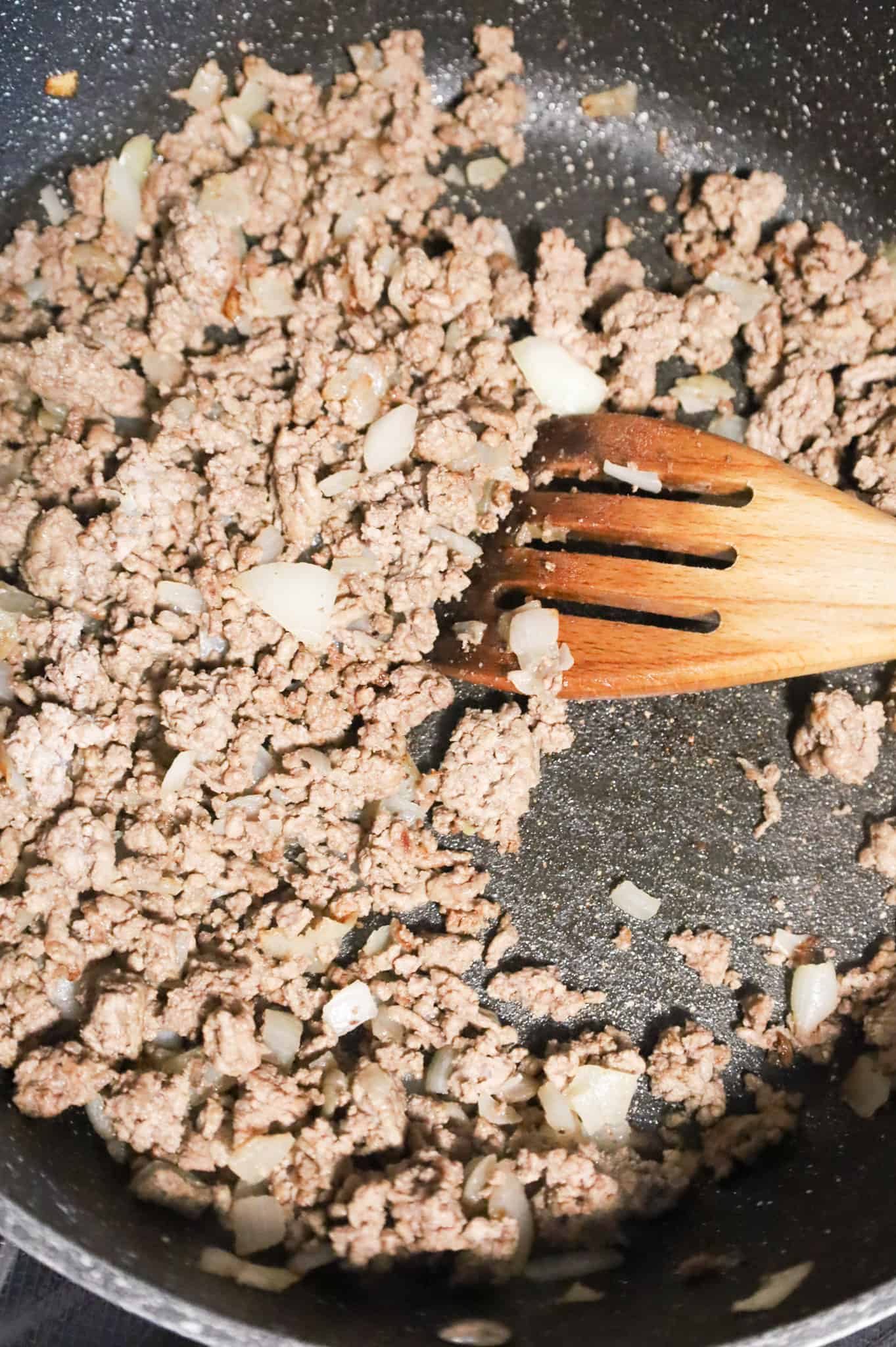 browned ground beef and diced onions in a skillet