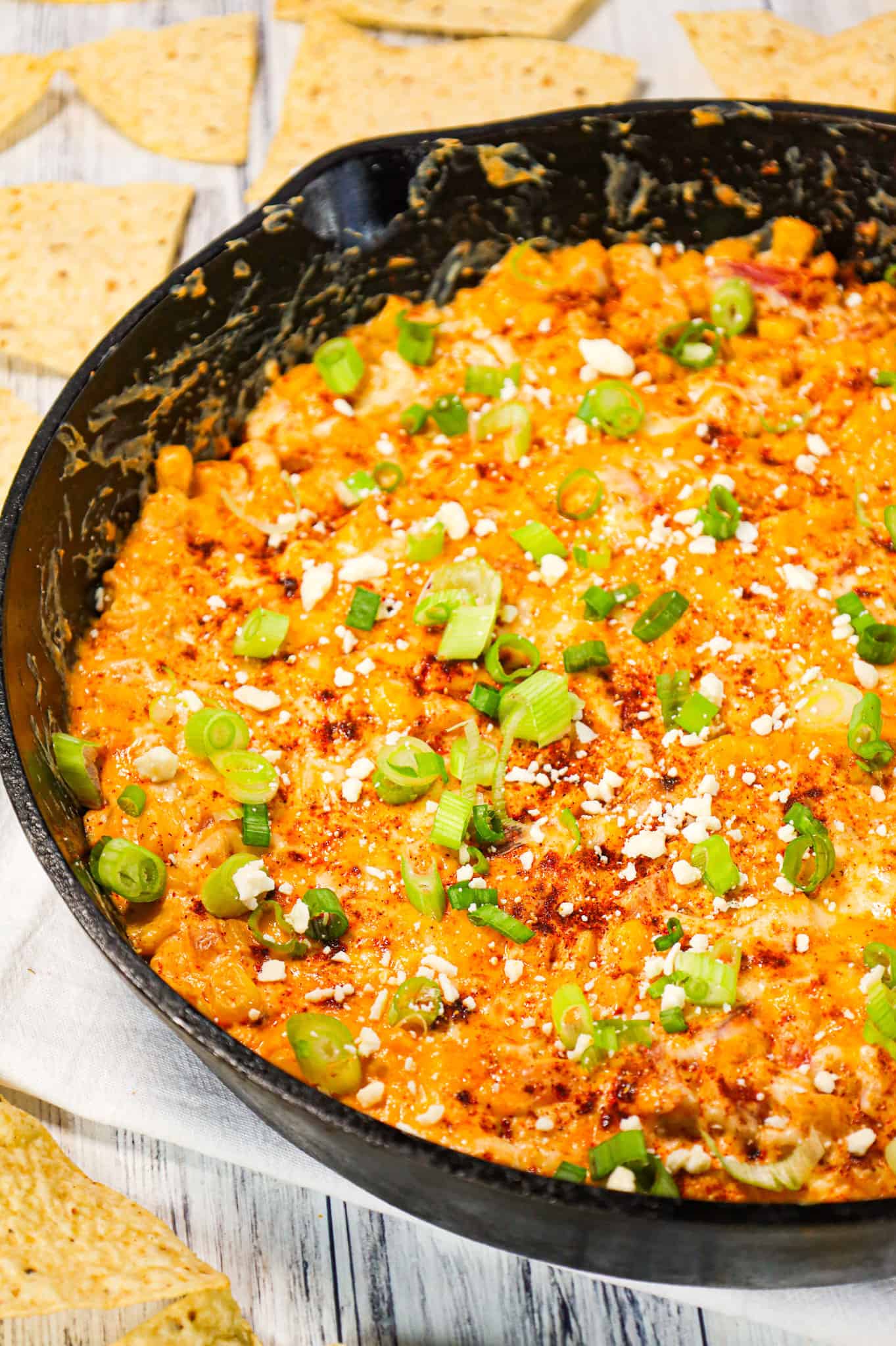 Mexican Street Corn Dip is a tasty hot party dip recipe loaded with corn, cream cheese, sour cream, chili powder, crumbled feta, red onions and shredded cheese.