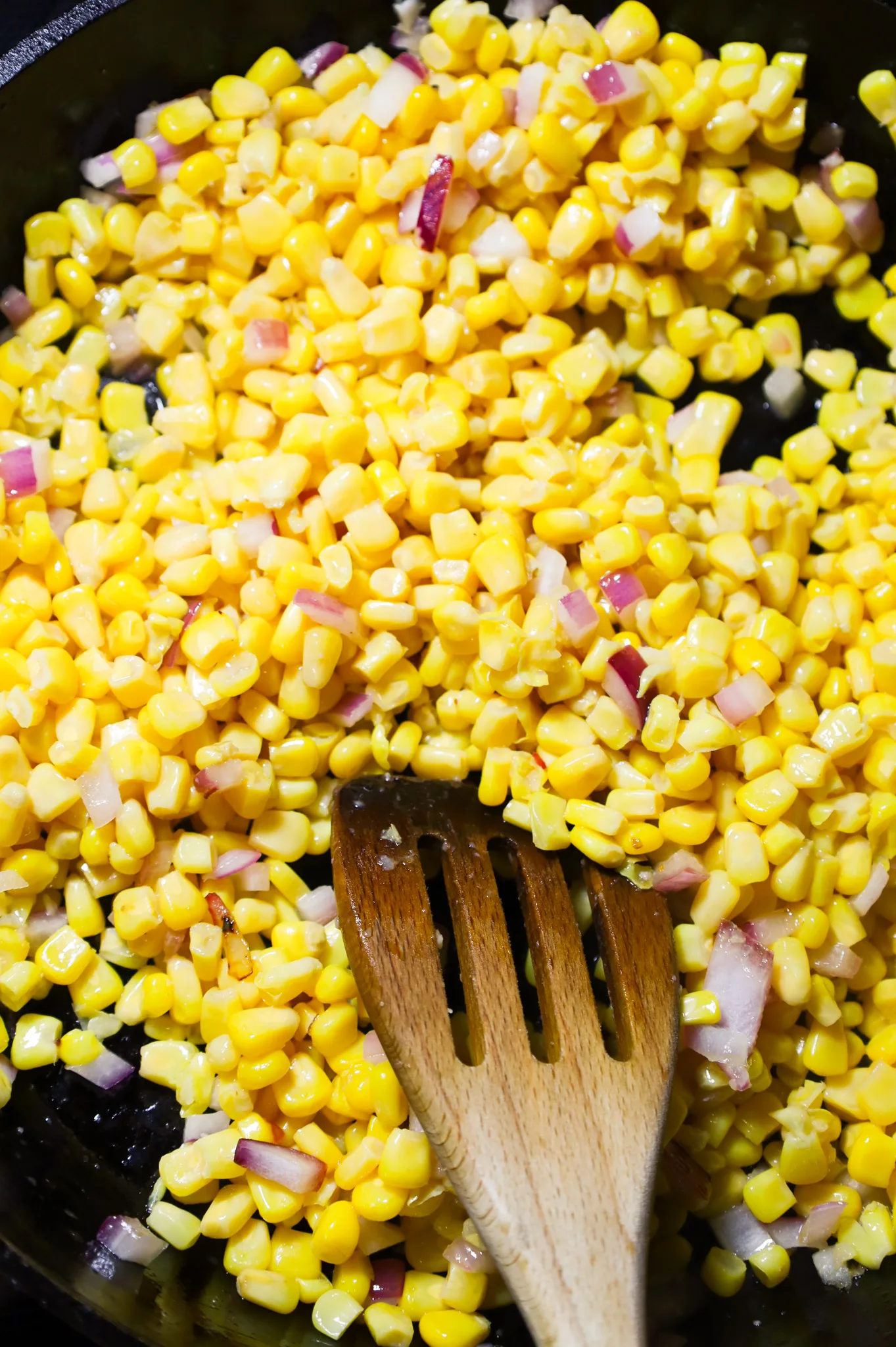 corn and diced red onions in a skillet
