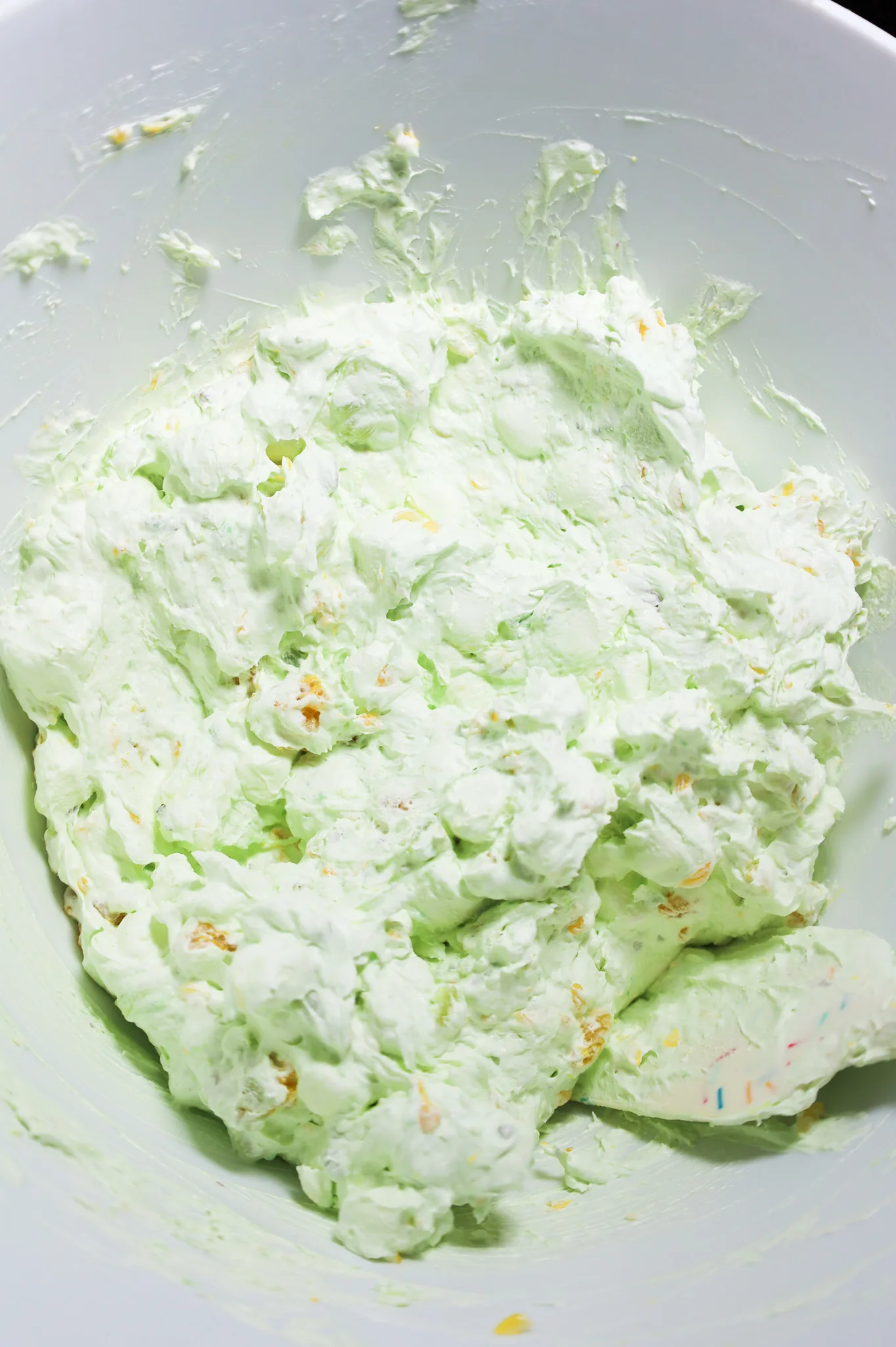 pistachio fluff salad mixture in a mixing bowl