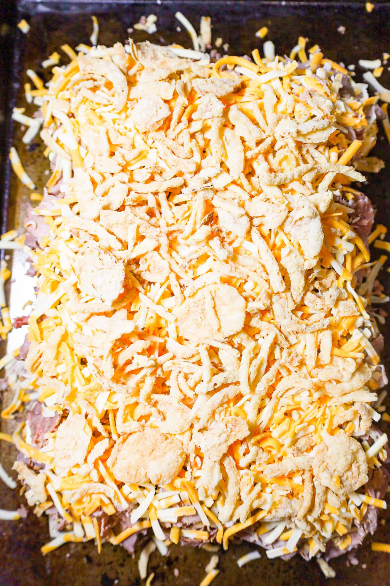 crispy fried onions on top of shredded cheese