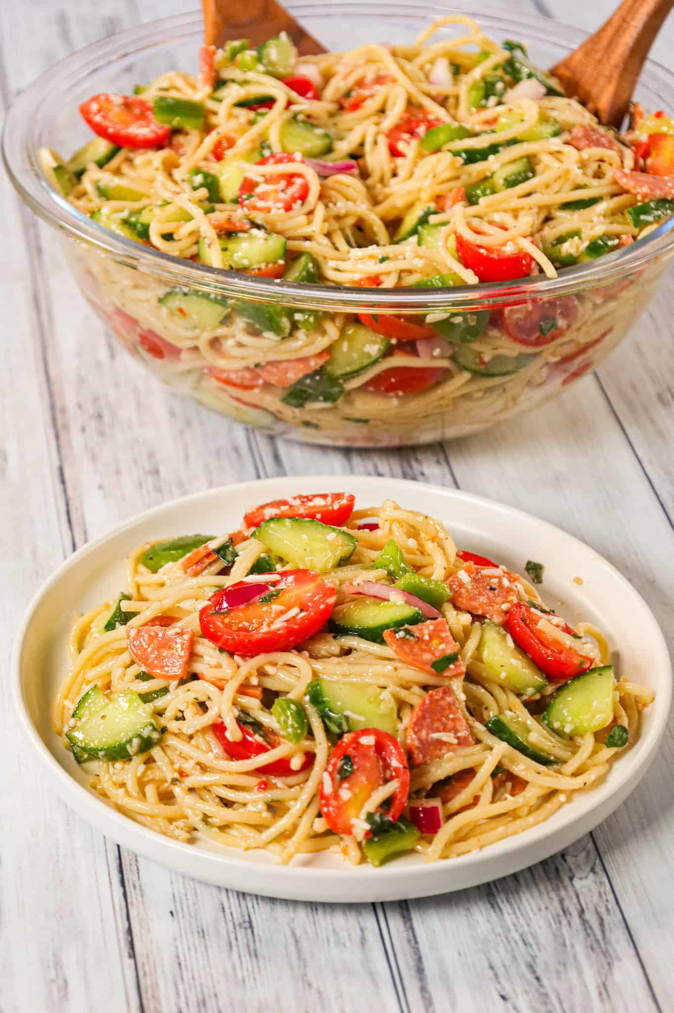 Spaghetti Salad is a tasty pasta salad recipe loaded with cucumbers, grape tomatoes, green peppers, red onions, pepperoni and grated parmesan all tossed in Italian dressing.