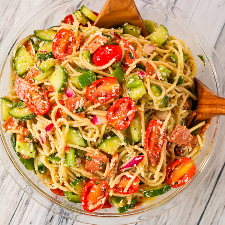 Spaghetti Salad is a tasty pasta salad recipe loaded with cucumbers, grape tomatoes, green peppers, red onions, pepperoni and grated parmesan all tossed in Italian dressing.
