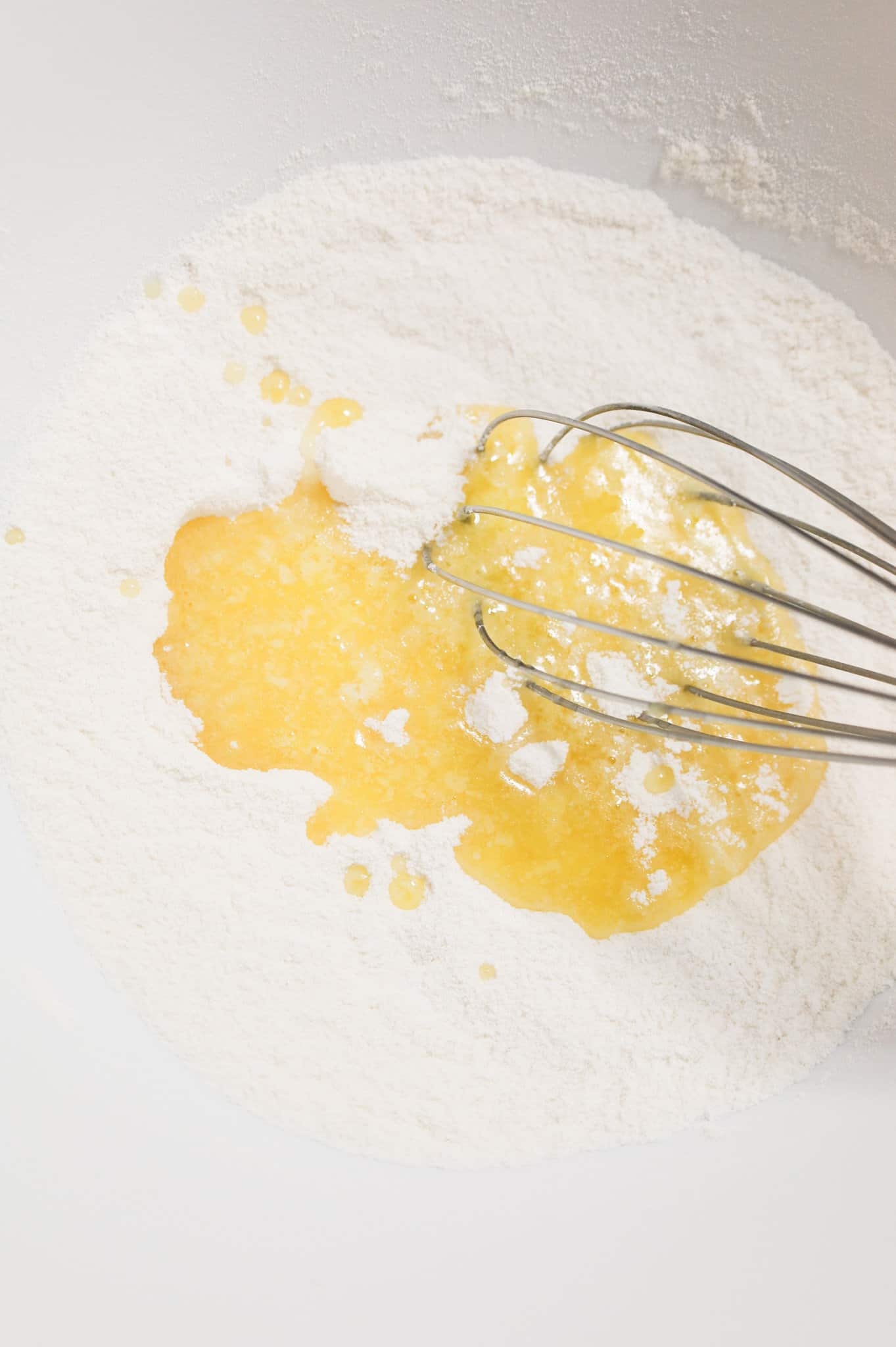 melted butter added to dry ingredients in a mixing bowl