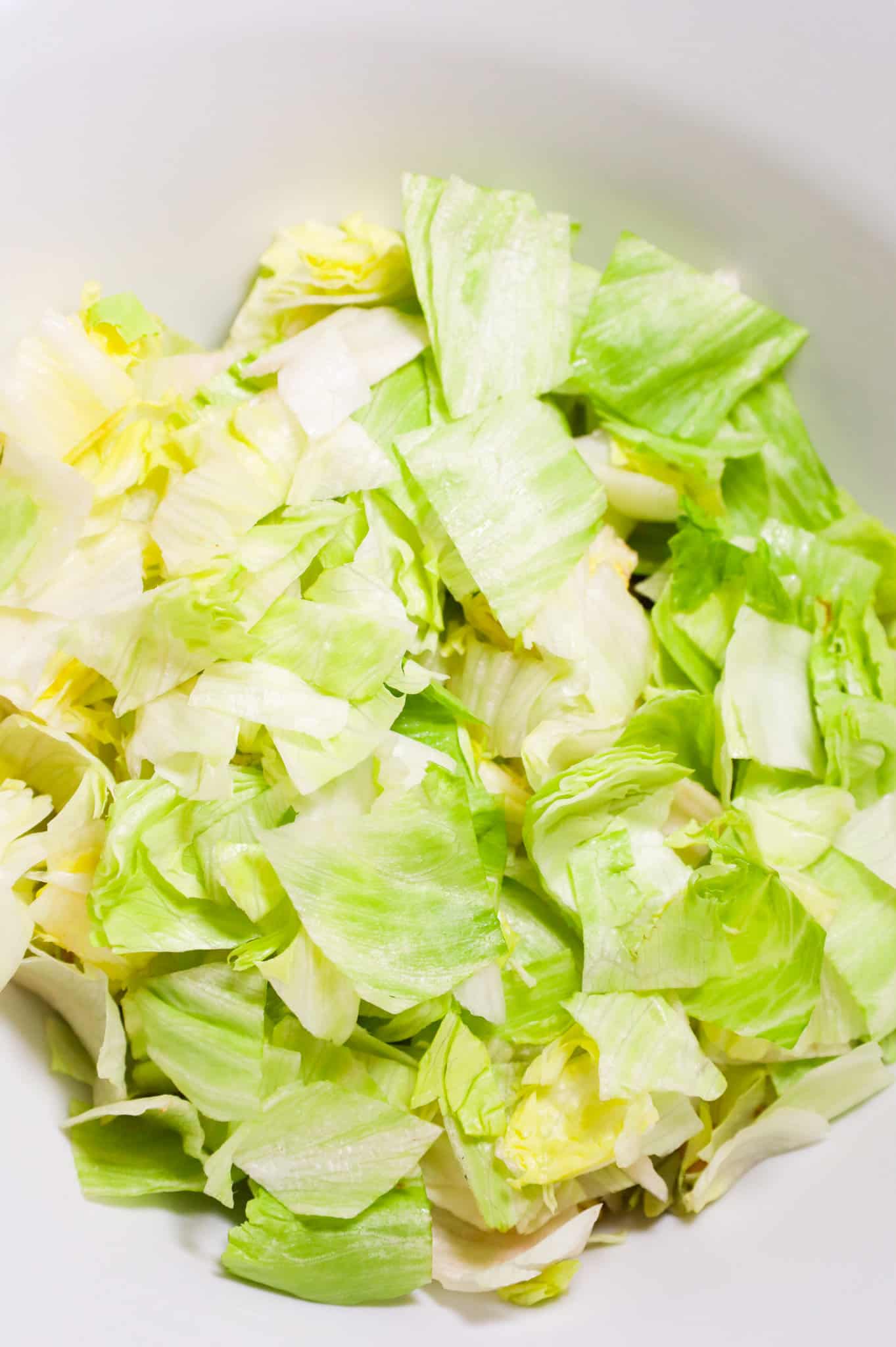 chopped iceberg lettuce in a mixing bowl