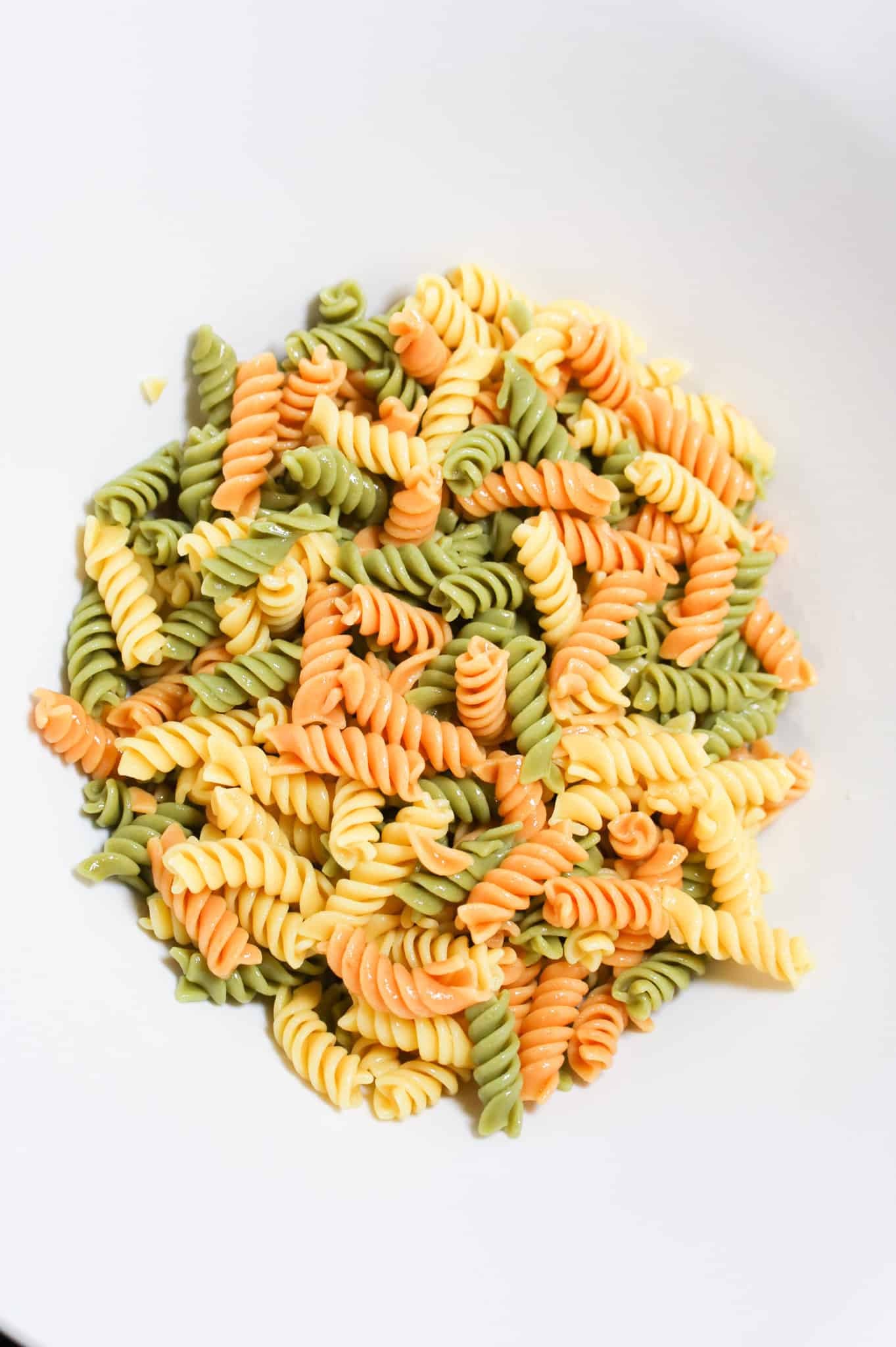cooked tri colour pasta in a large mixing bowl