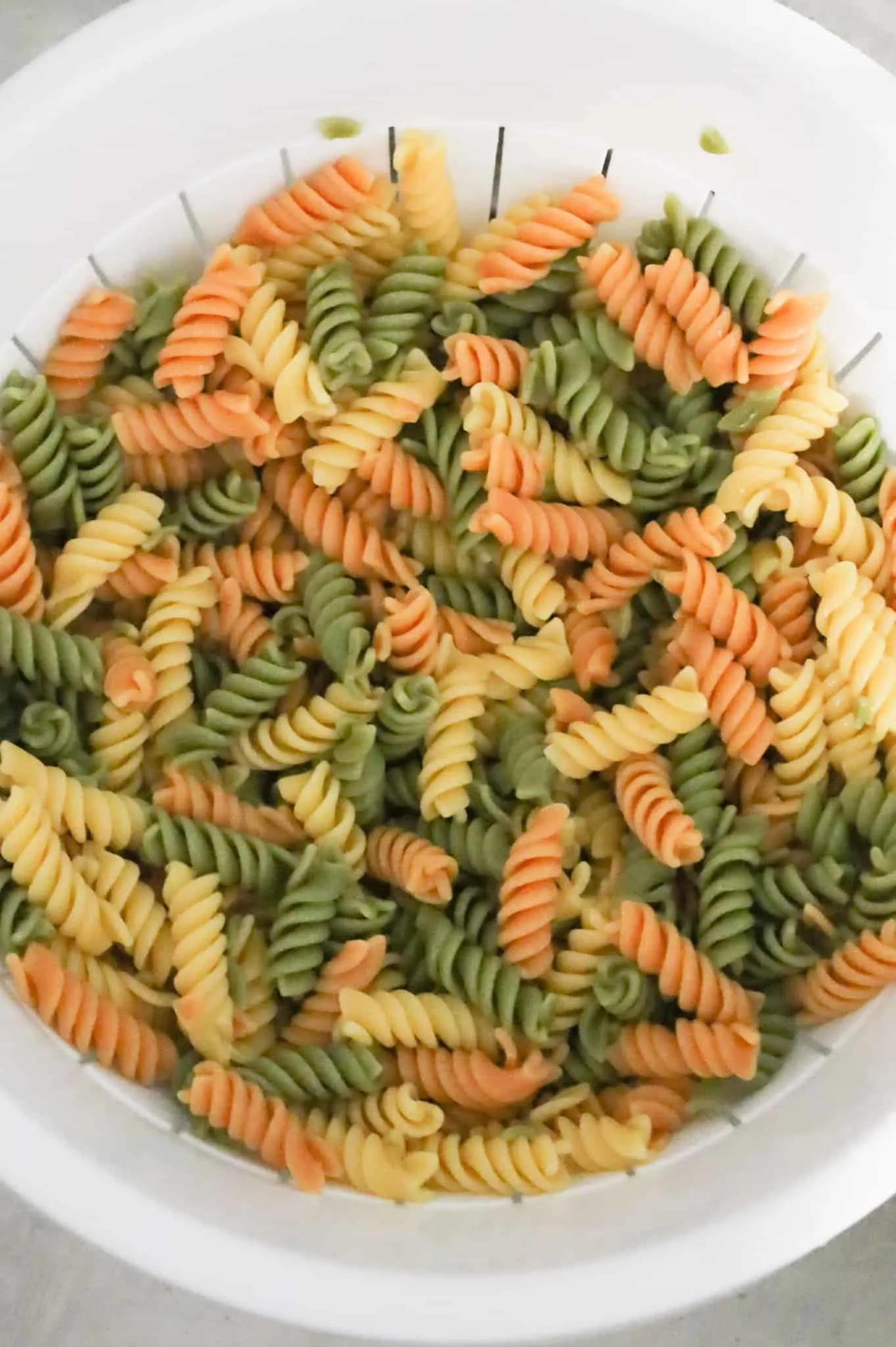 cooked tri colour rotini pasta in a colander