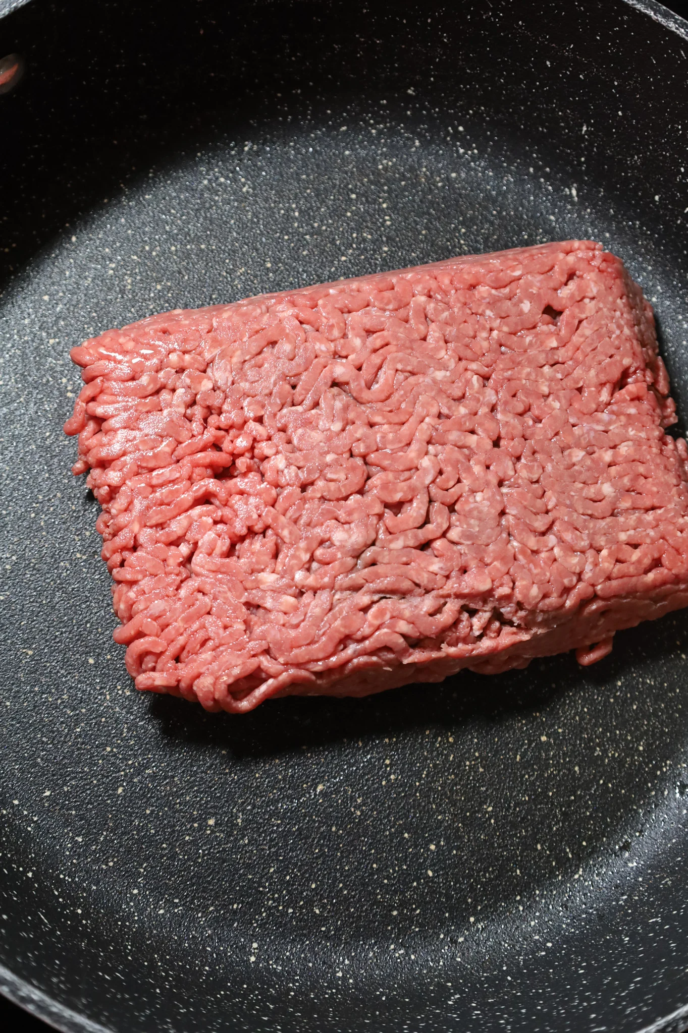 raw ground beef in a large skillet