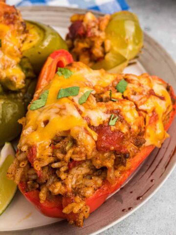 Taco Stuffed Peppers are an easy weeknight dinner recipe made with bell peppers stuffed with a ground beef, rice and taco sauce mixture and baked with cheese on top.
