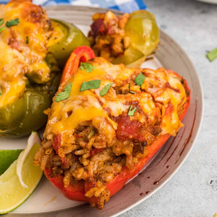 Taco Stuffed Peppers are an easy weeknight dinner recipe made with bell peppers stuffed with a ground beef, rice and taco sauce mixture and baked with cheese on top.