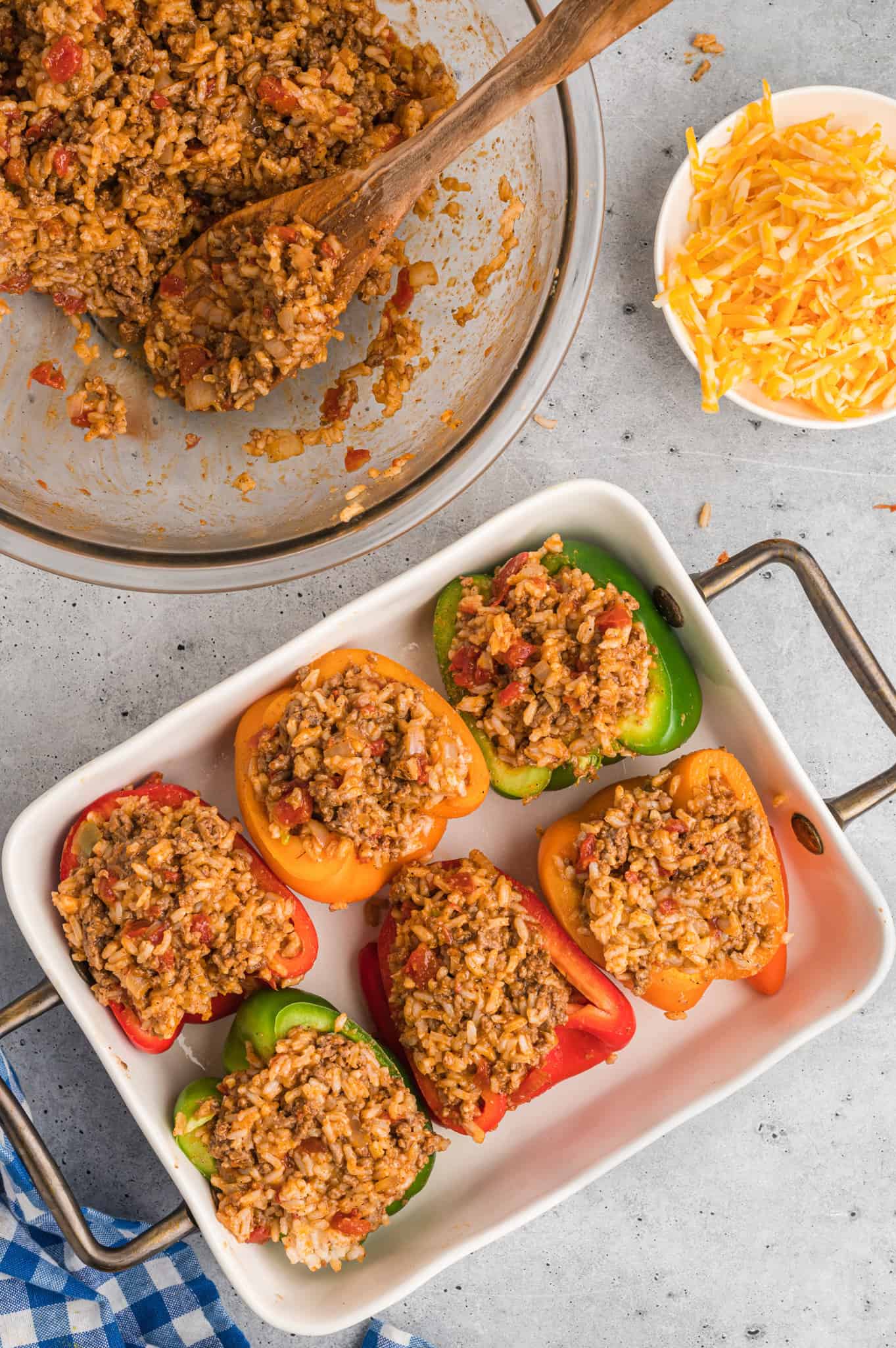 ground beef and rice mixture stuffed in bell peppers on a baking sheet