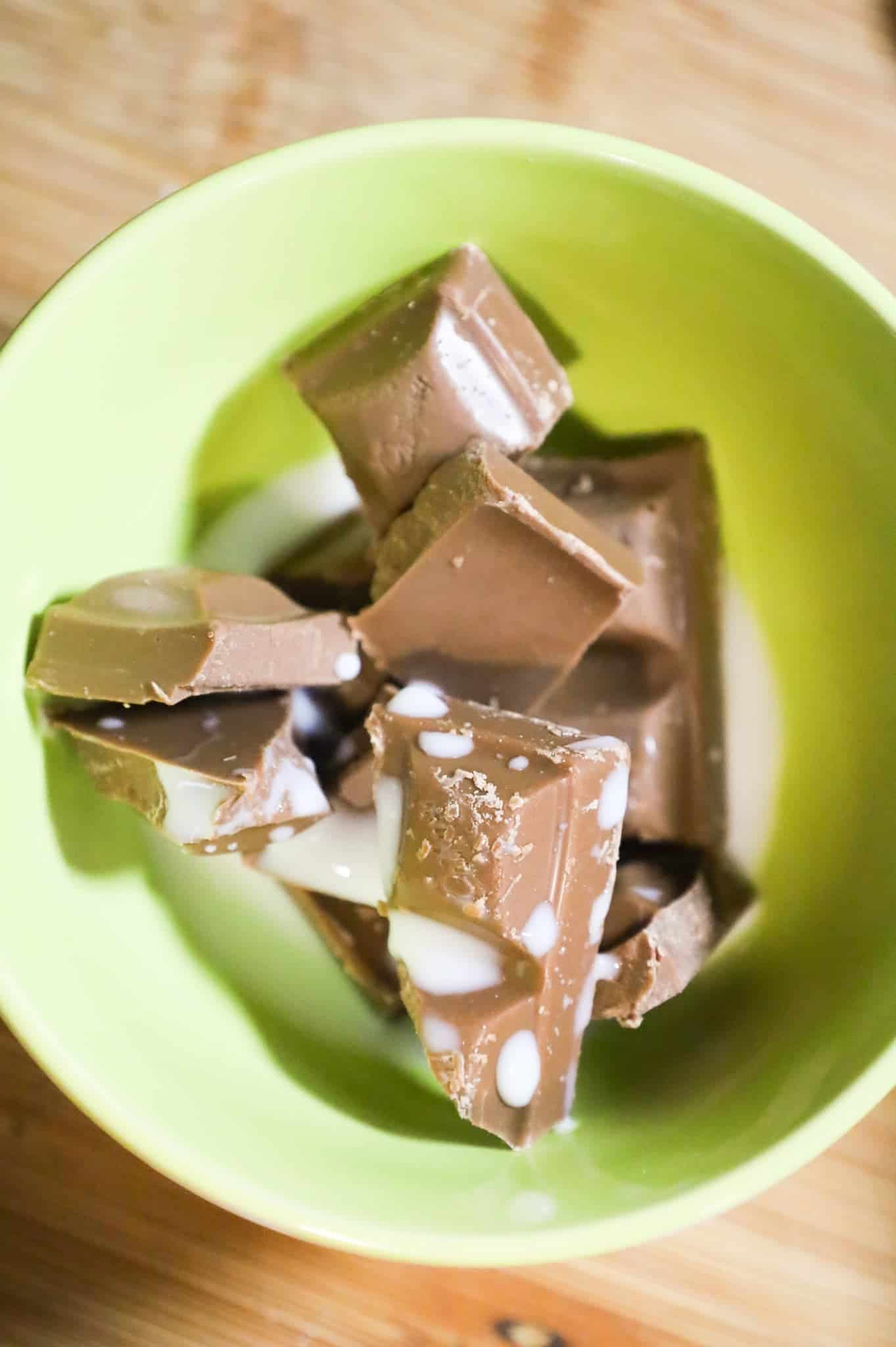 milk chocolate squares and milk in a small bowl