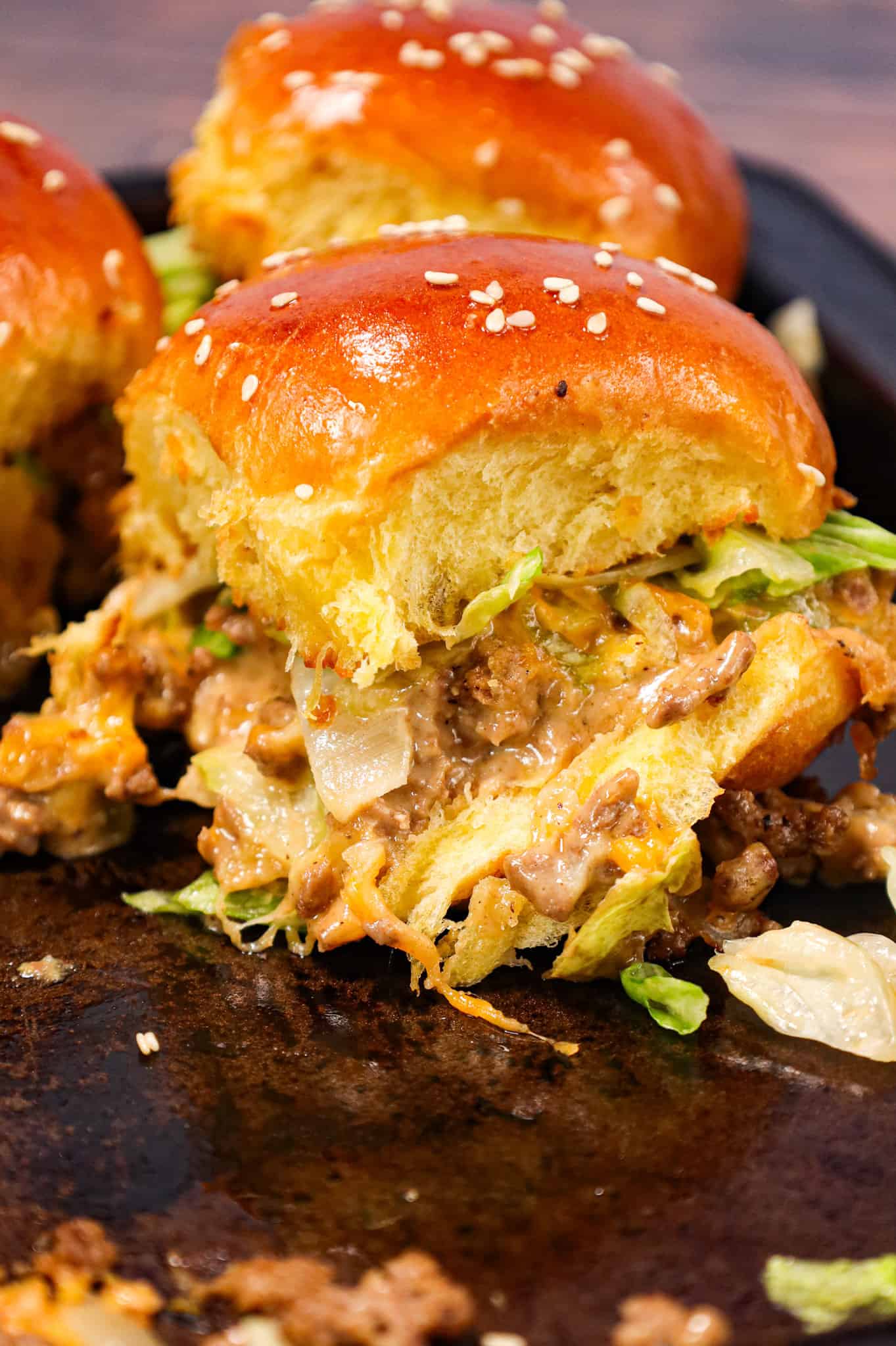 Big Mac Sliders are an easy weeknight dinner recipe made with ground beef, onion, pickles, mayo, Thousand Island dressing, cheddar cheese and shredded lettuce all piled on to dinner rolls topped with sesame seeds.