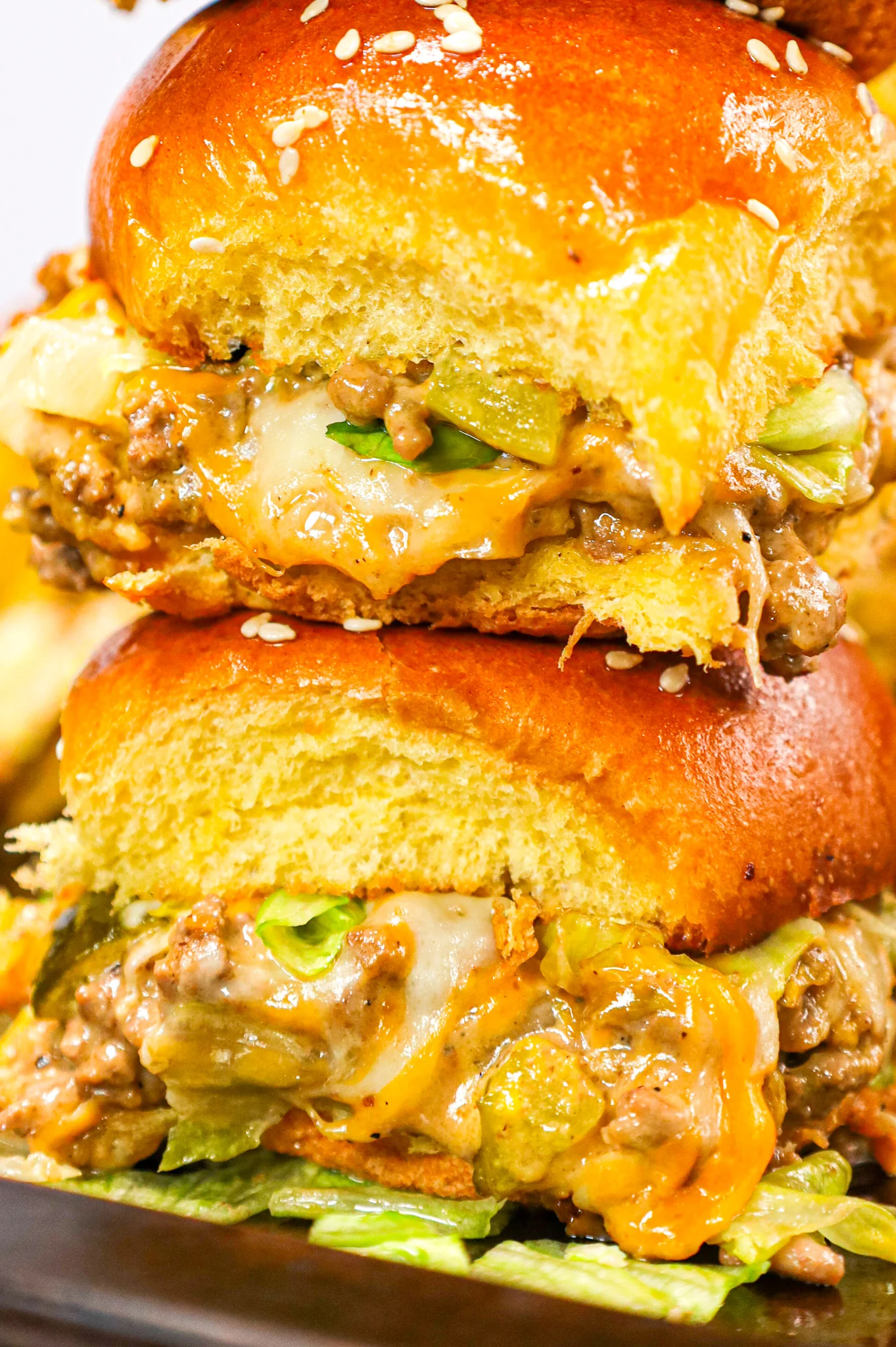 Big Mac Sliders are an easy weeknight dinner recipe made with ground beef, onion, pickles, mayo, Thousand Island dressing, cheddar cheese and shredded lettuce all piled on to dinner rolls topped with sesame seeds.