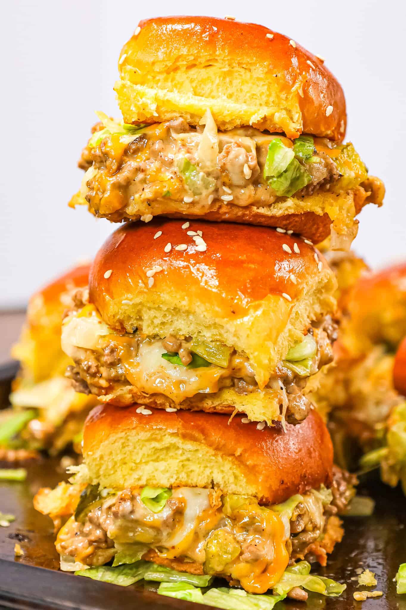 Big Mac Sliders are an easy weeknight dinner recipe made with ground beef, onion, pickles, mayo, Thousand Island dressing, cheddar cheese and shredded lettuce all piled on to dinner rolls topped with sesame seeds.