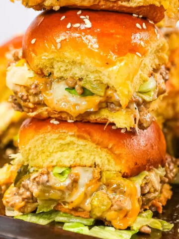 Big Mac Sliders are an easy weeknight dinner recipe made with ground beef, onion, pickles, mayo, Thousand Island dressing, cheddar cheese and shredded lettuce all piled on to dinner rolls topped with sesame seeds.