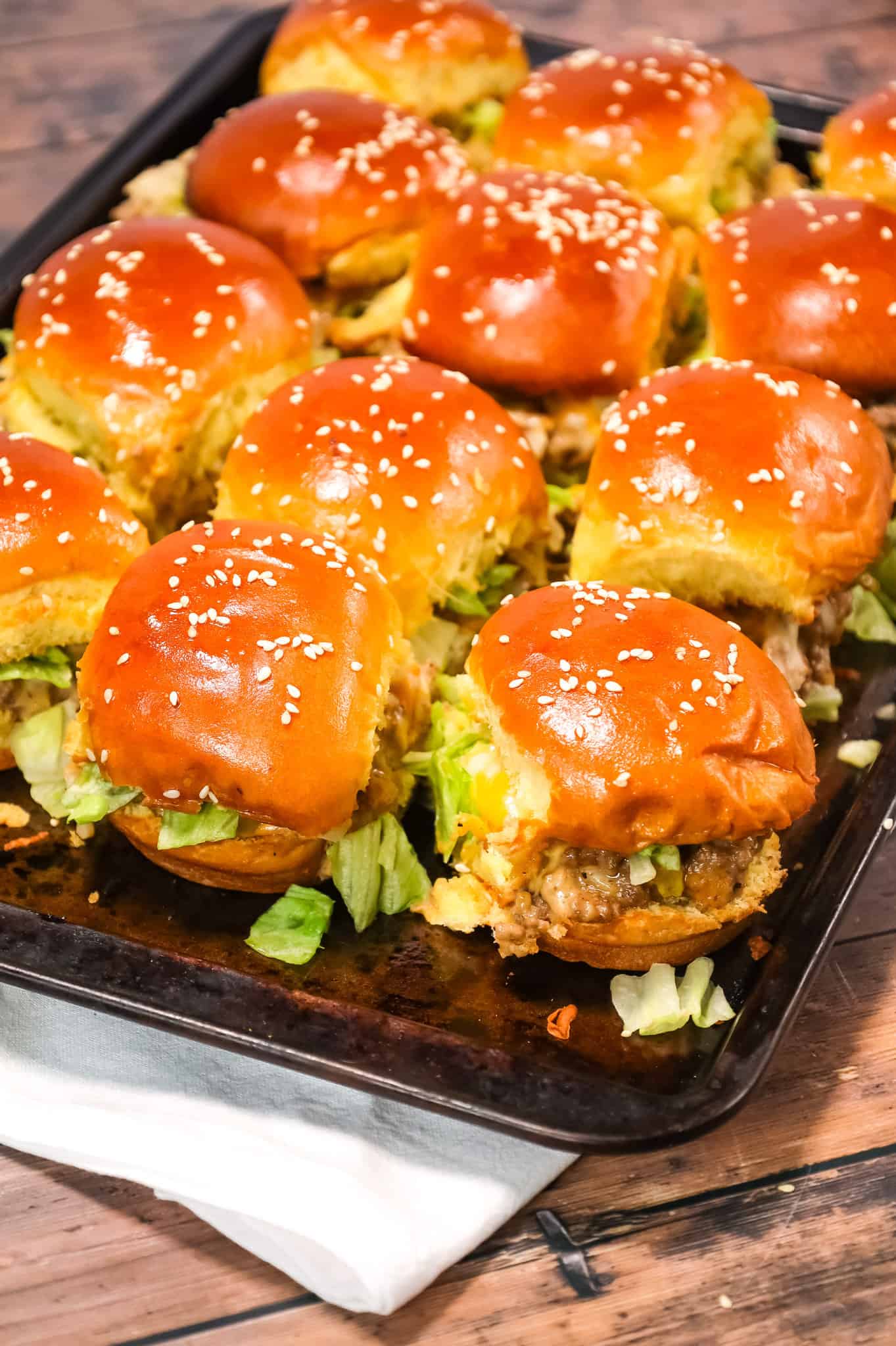 Big Mac Sliders are an easy weeknight dinner recipe made with ground beef, onion, pickles, mayo, Thousand Island dressing, cheddar cheese and shredded lettuce all piled on to dinner rolls topped with sesame seeds.