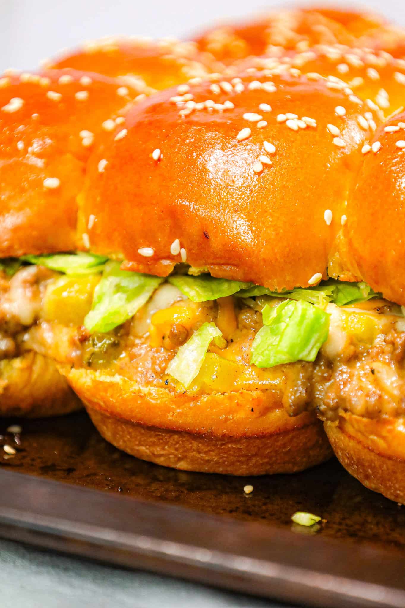 Big Mac Sliders are an easy weeknight dinner recipe made with ground beef, onion, pickles, mayo, Thousand Island dressing, cheddar cheese and shredded lettuce all piled on to dinner rolls topped with sesame seeds.