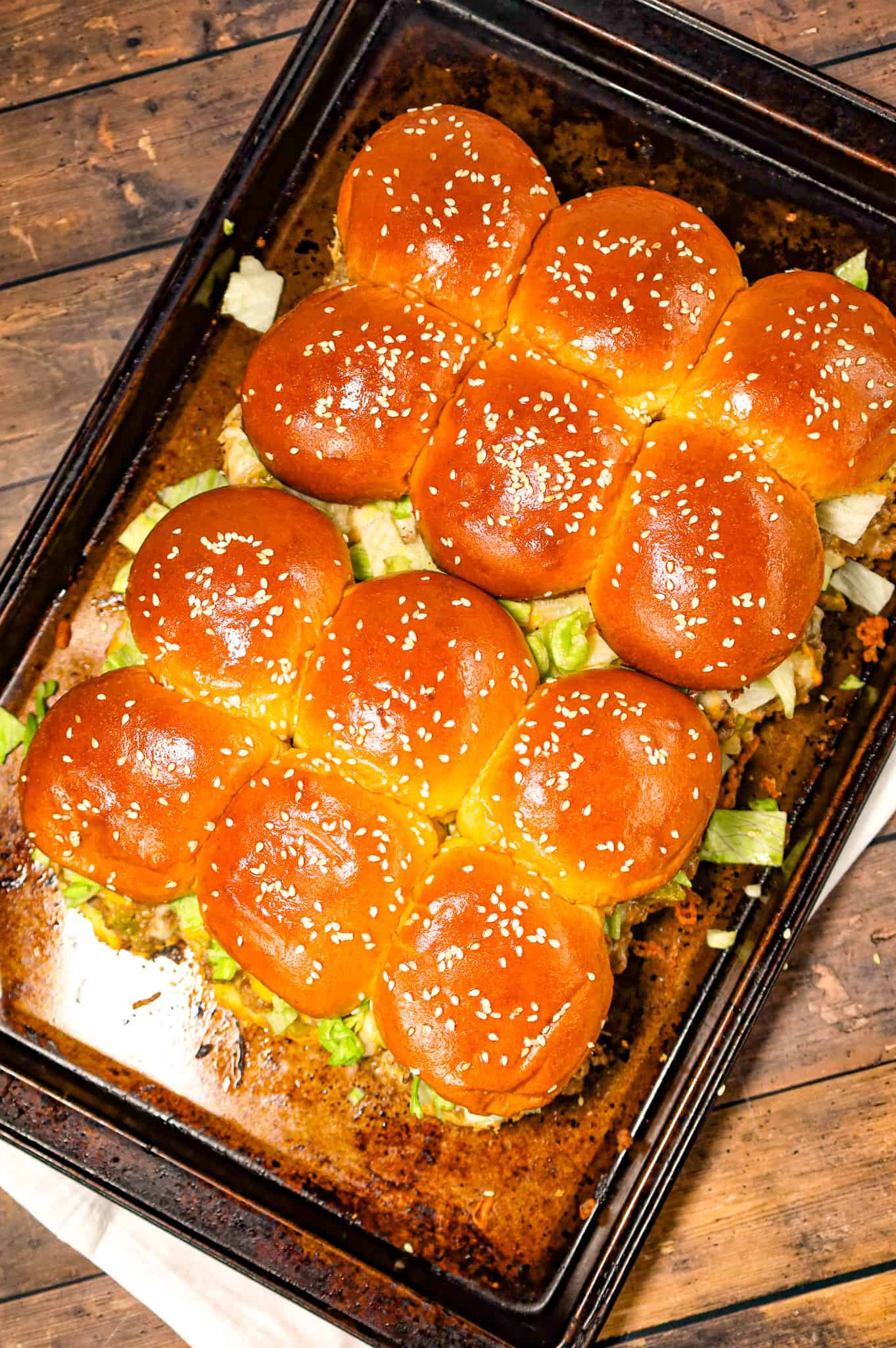 Big Mac Sliders are an easy weeknight dinner recipe made with ground beef, onion, pickles, mayo, Thousand Island dressing, cheddar cheese and shredded lettuce all piled on to dinner rolls topped with sesame seeds.