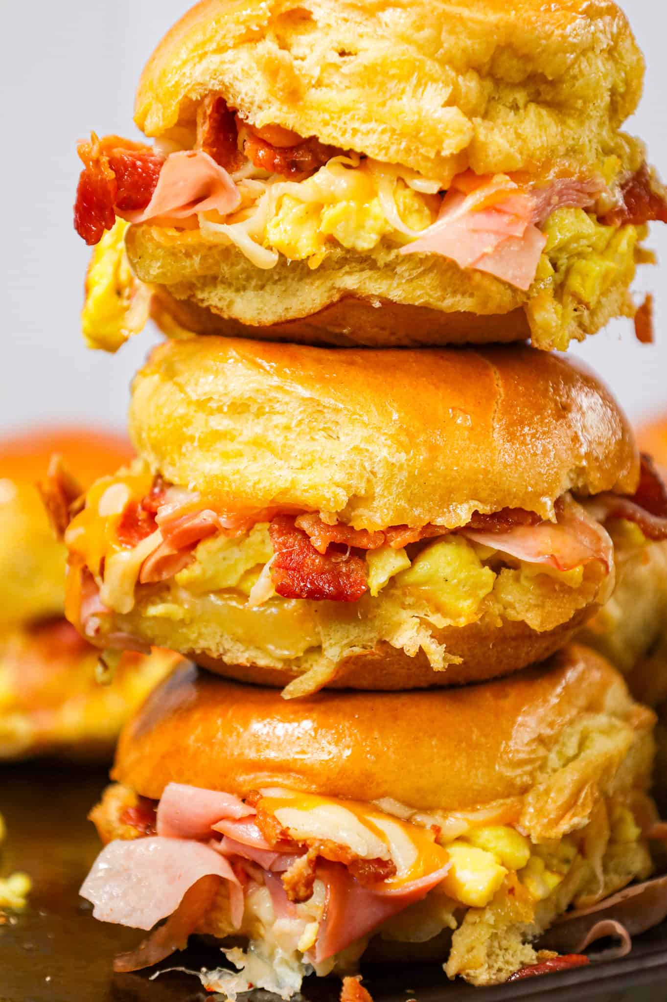 Breakfast Sliders are small pull apart breakfast sandwiches loaded with scrambled eggs, ham, bacon and cheese.