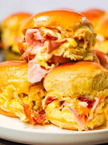 Breakfast Sliders are small pull apart breakfast sandwiches loaded with scrambled eggs, ham, bacon and cheese.