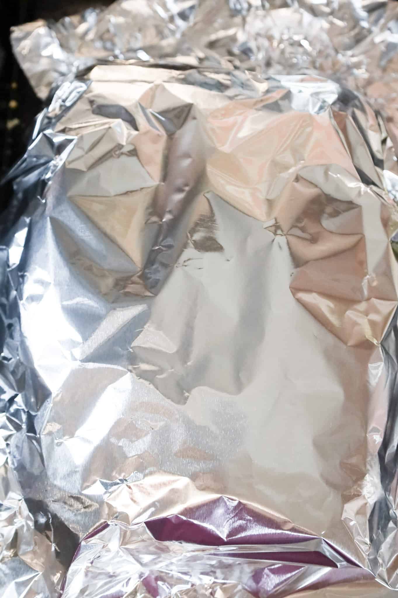 aluminum foil covering breakfast sliders on a baking sheet