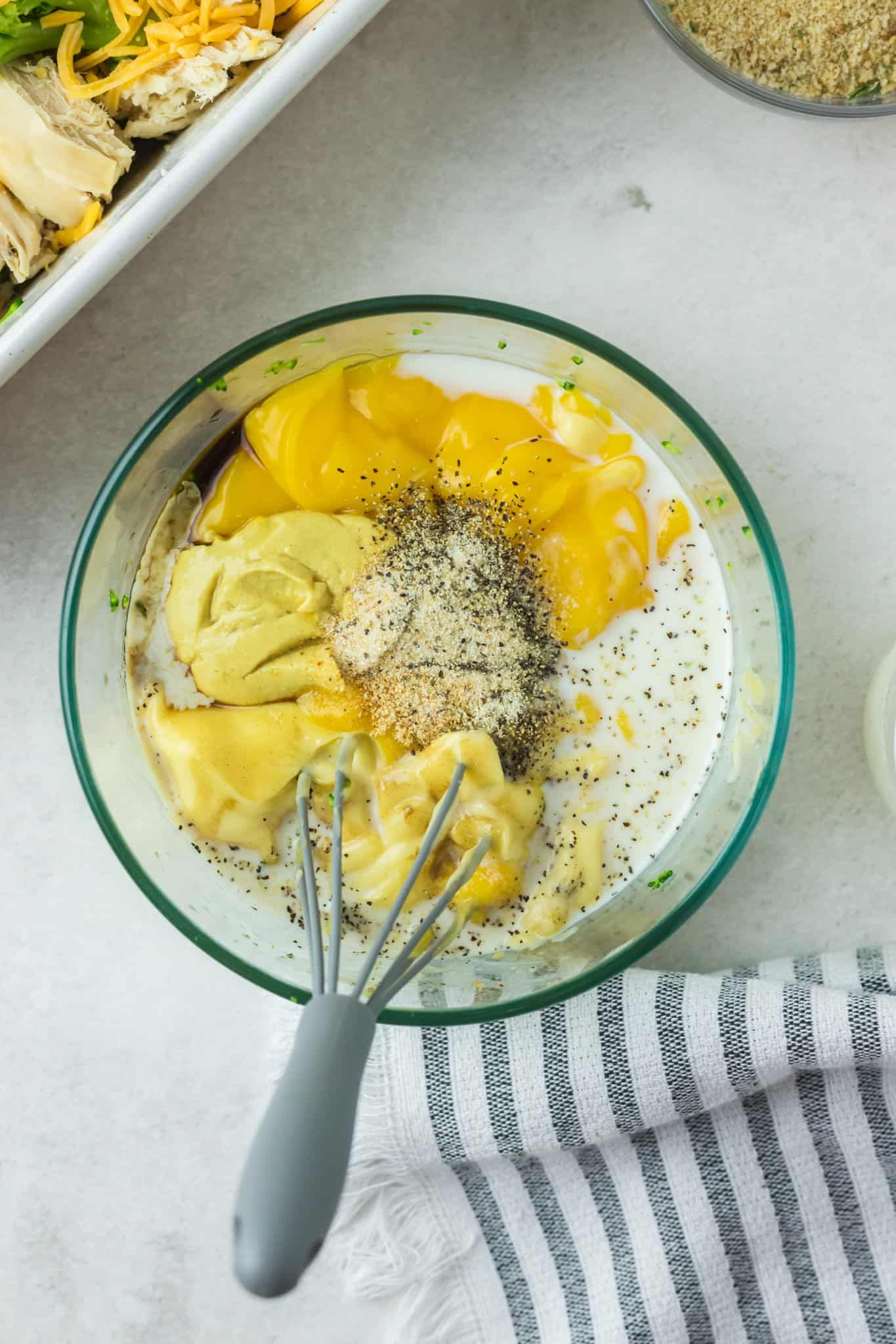 cream of chicken soup, cheddar soup, milk and spices in a mixing bowl