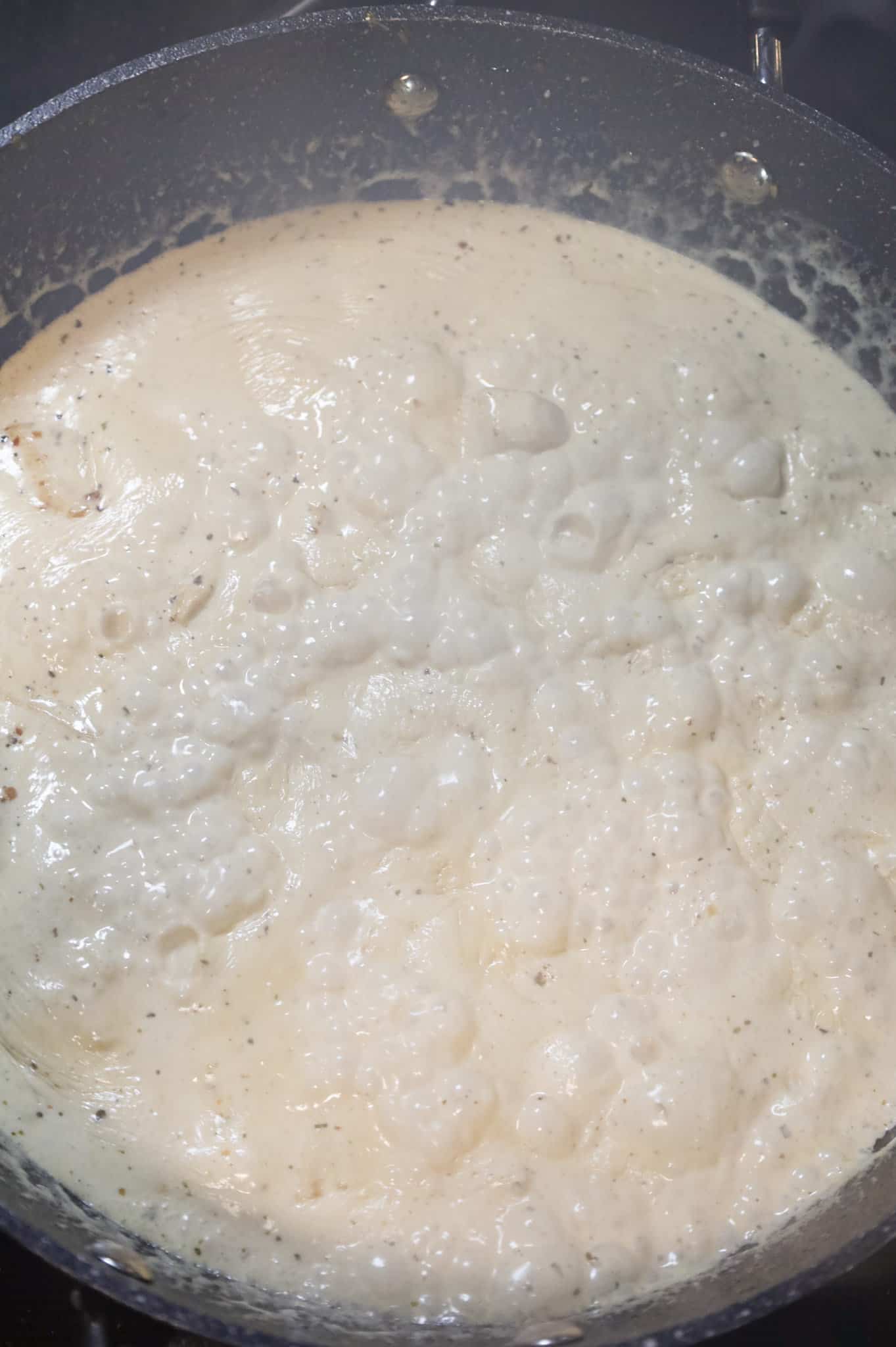 heavy cream boiling in a skillet