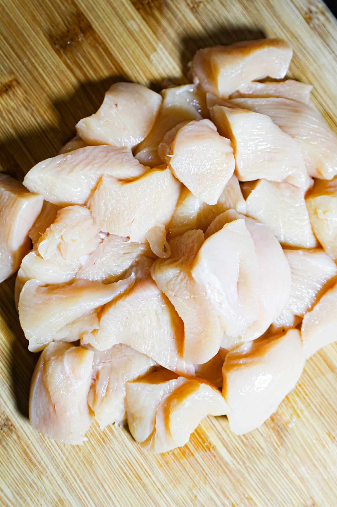 raw chicken breast chunks on a cutting board