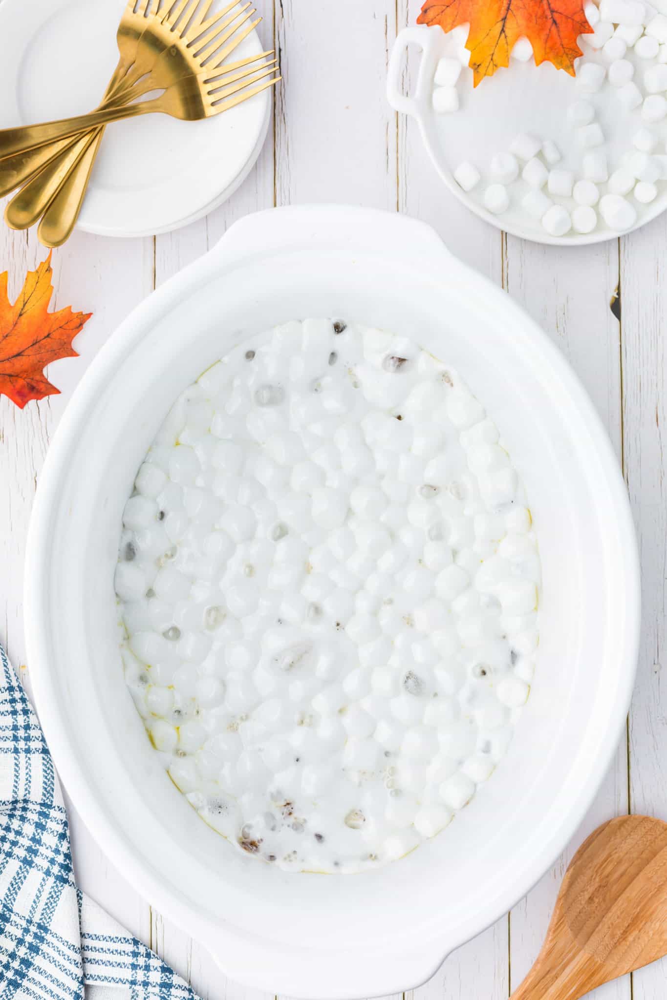 melted mini marshmallows on top of sweet potato casserole in a crock pot