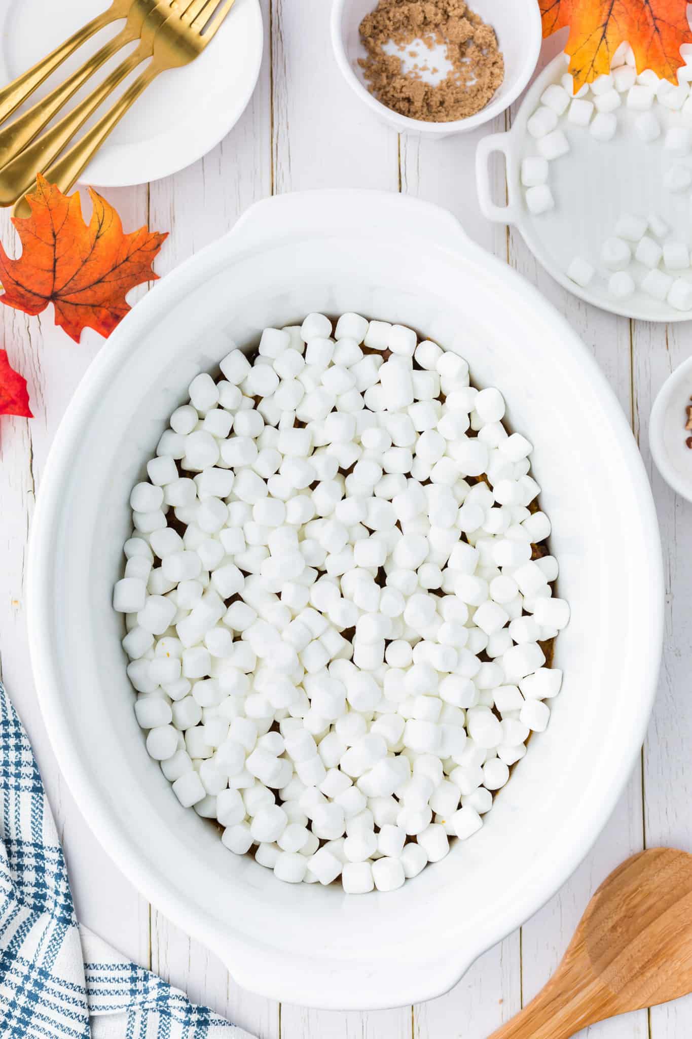 mini marshmallows on top of sweet potato casserole in a crock pot