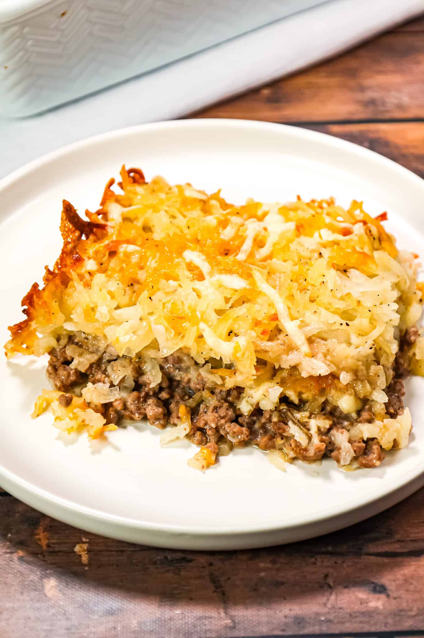 Hamburger Hashbrown Casserole is an easy ground beef dinner recipe loaded with shredded hashbrown potatoes, cream of mushroom soup and shredded mozzarella and cheddar cheese.