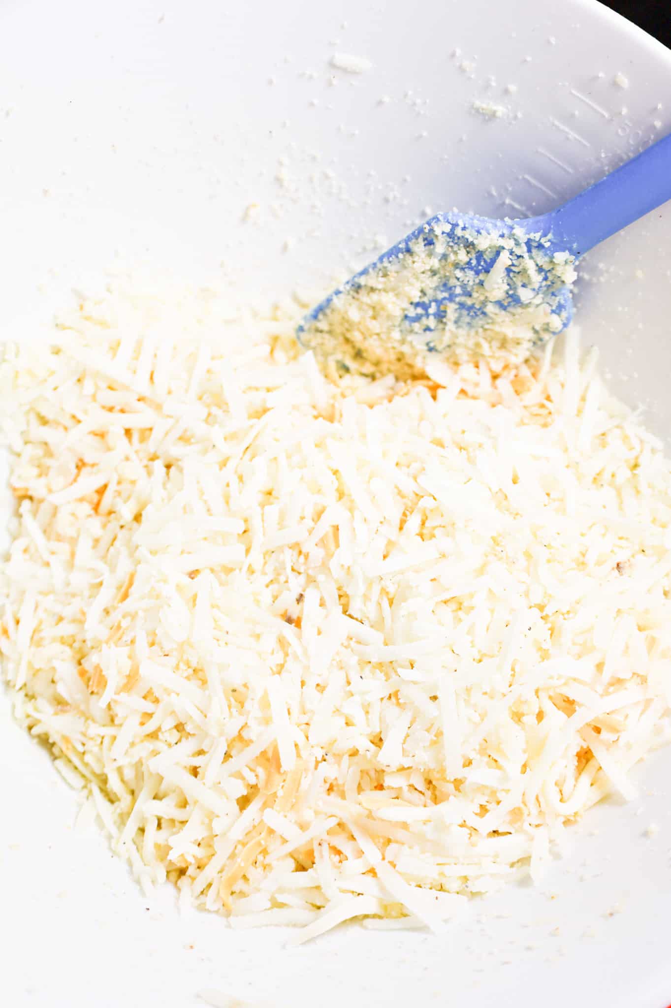 shredded cheese and hashbrown mixture in a mixing bowl