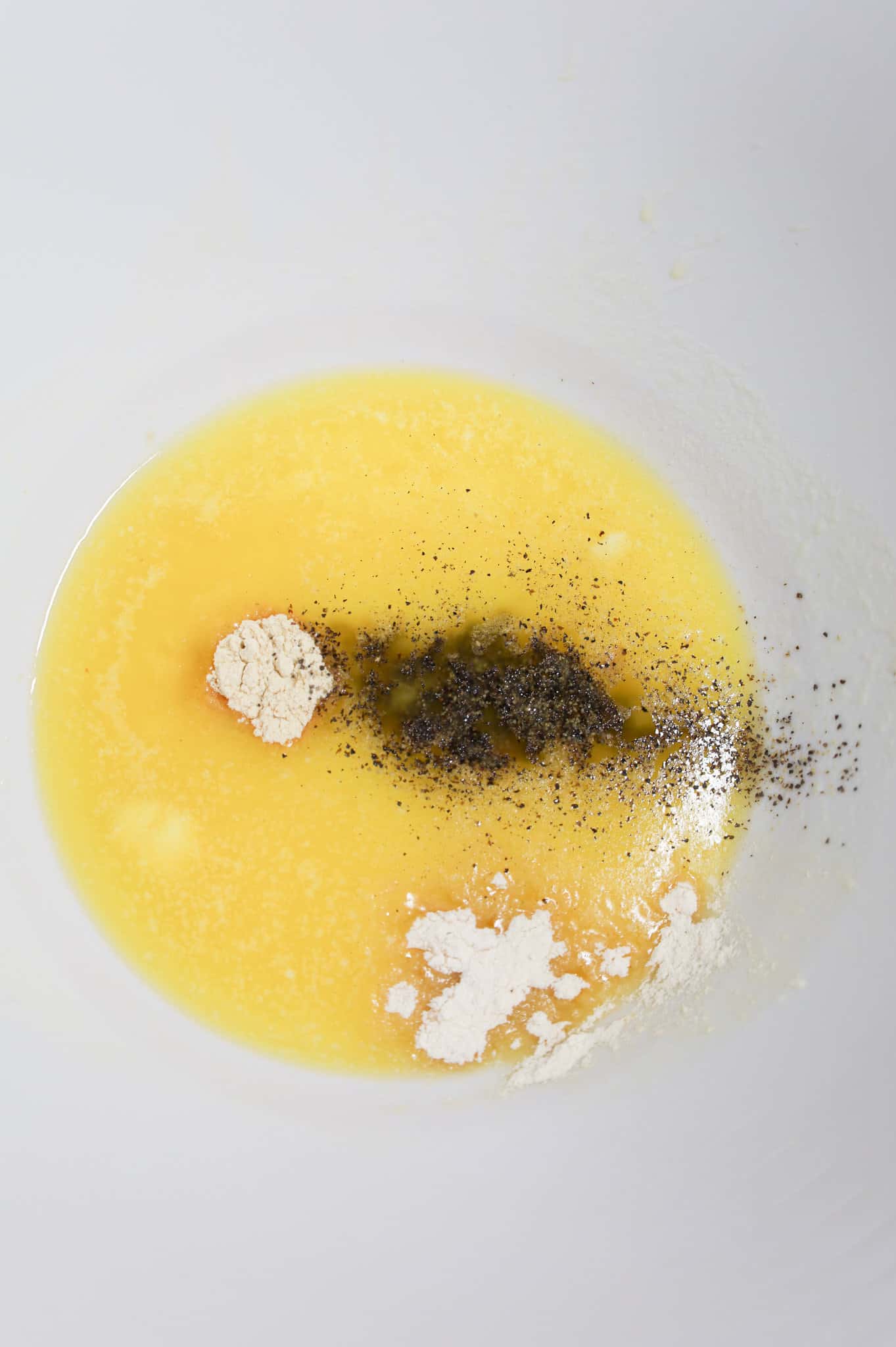 spices on top of melted butter in a mixing bowl