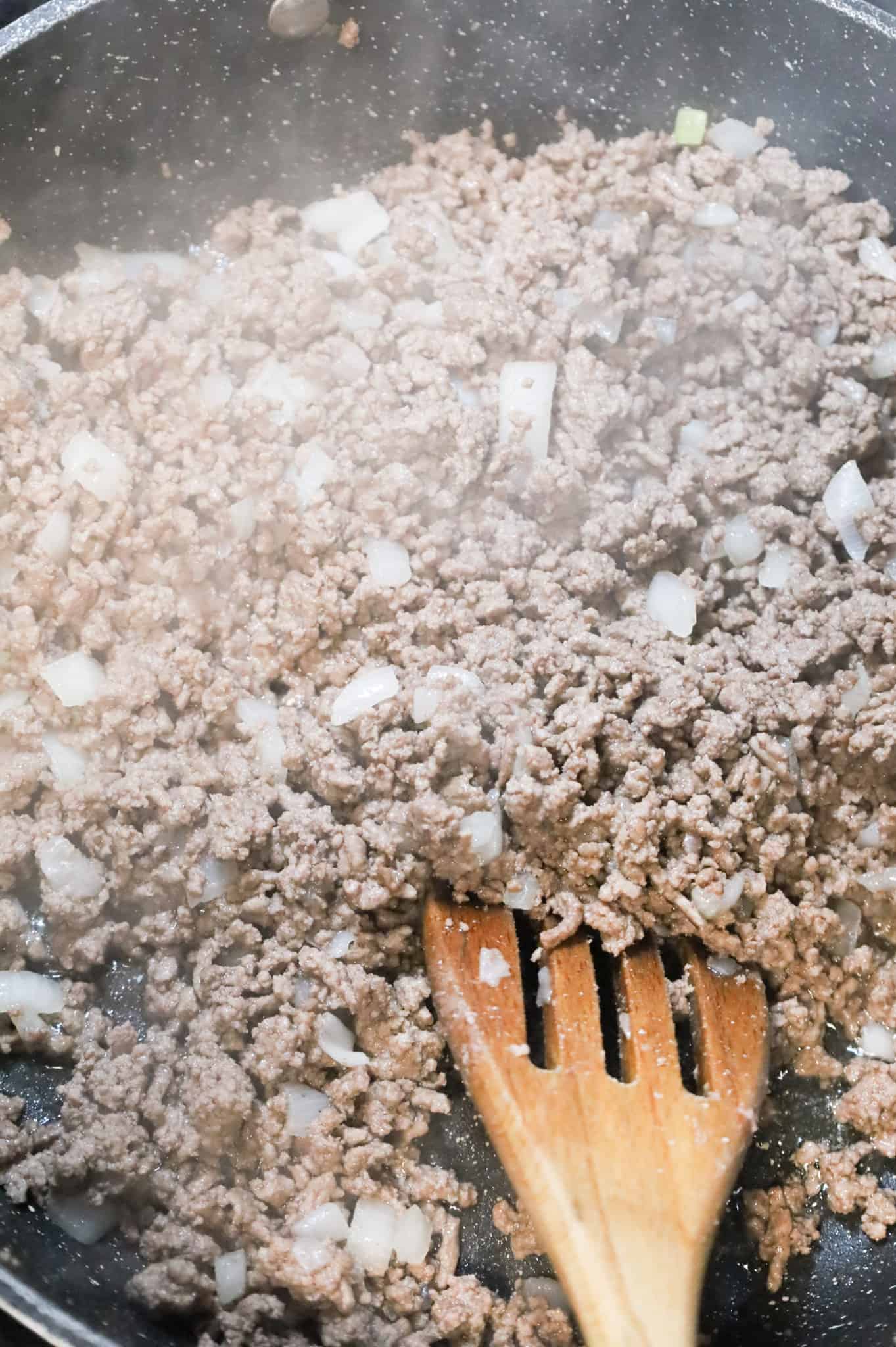 cooked ground beef and diced onions in a skillet