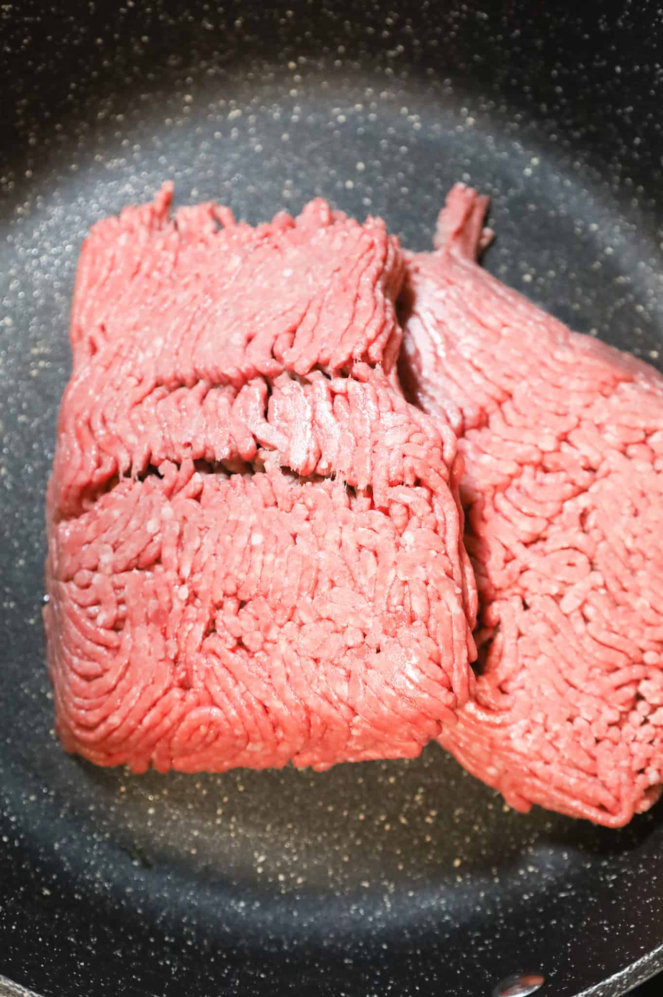 raw ground beef in a skillet