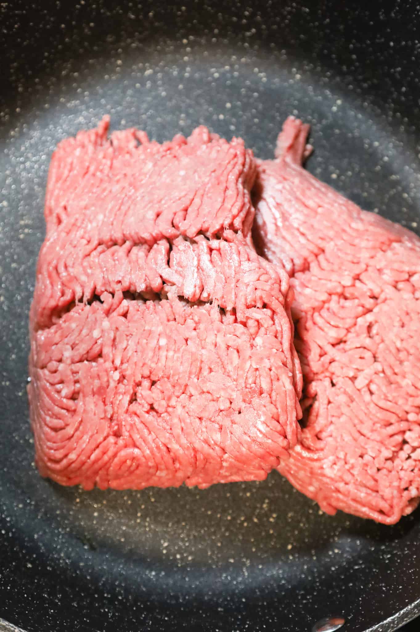 raw ground beef in a skillet