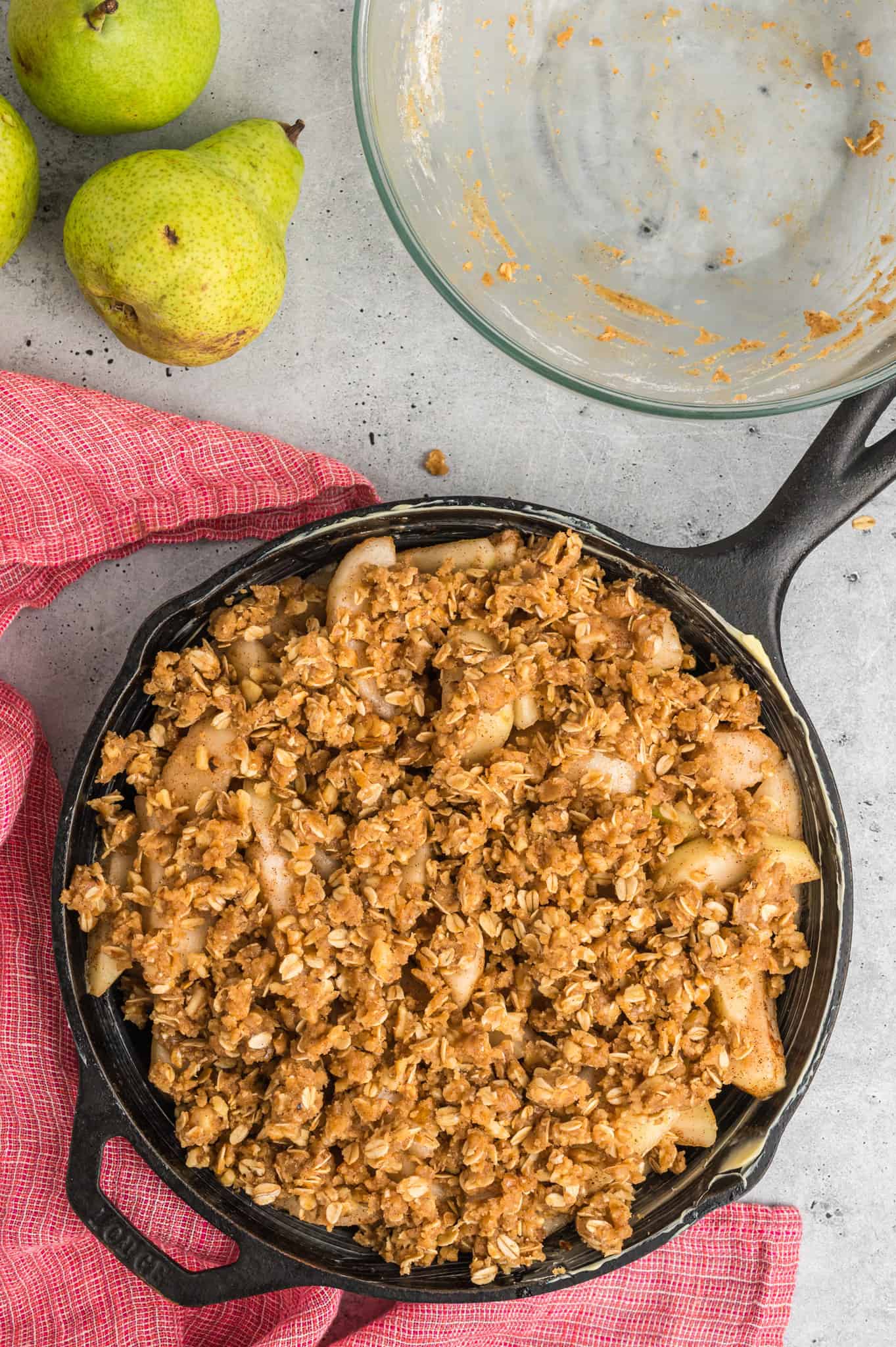 brown sugar oat crumble mixture on top of pear slices in a skillet
