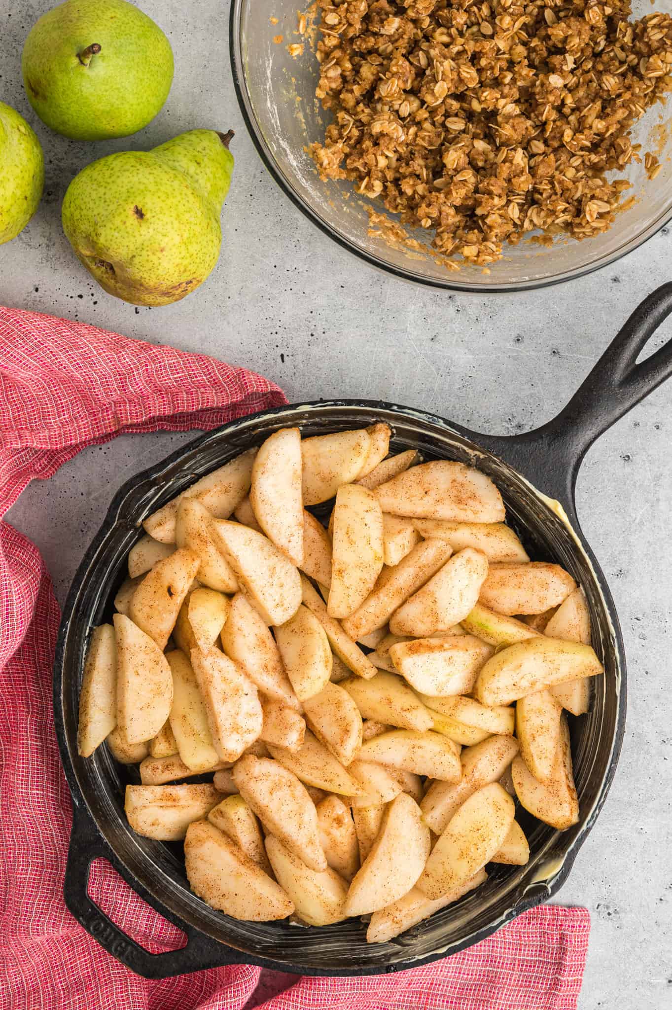 pear slices coated in sugar and apple pie spice in a skillet