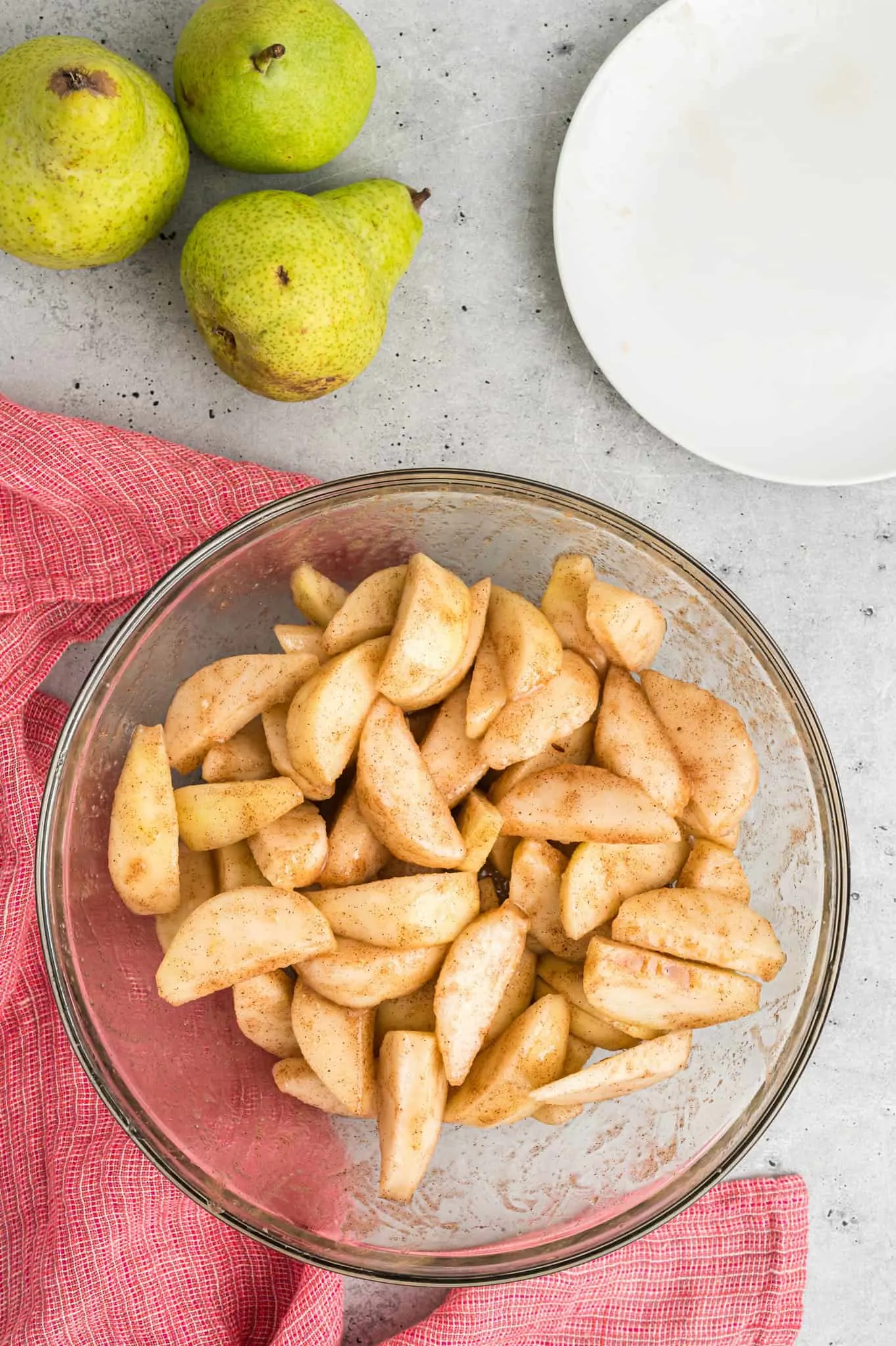 pear slices coated in sugar and apple pie spice in a bowl