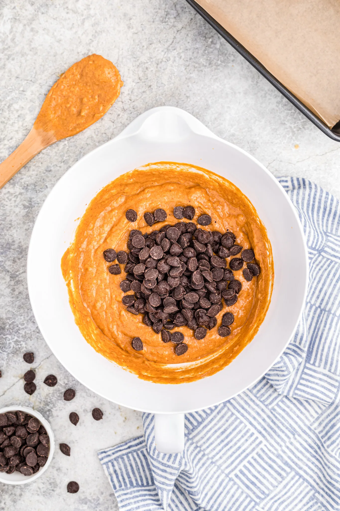 dark chocolate chips added to pumpkin bread batter in a mixing bowl