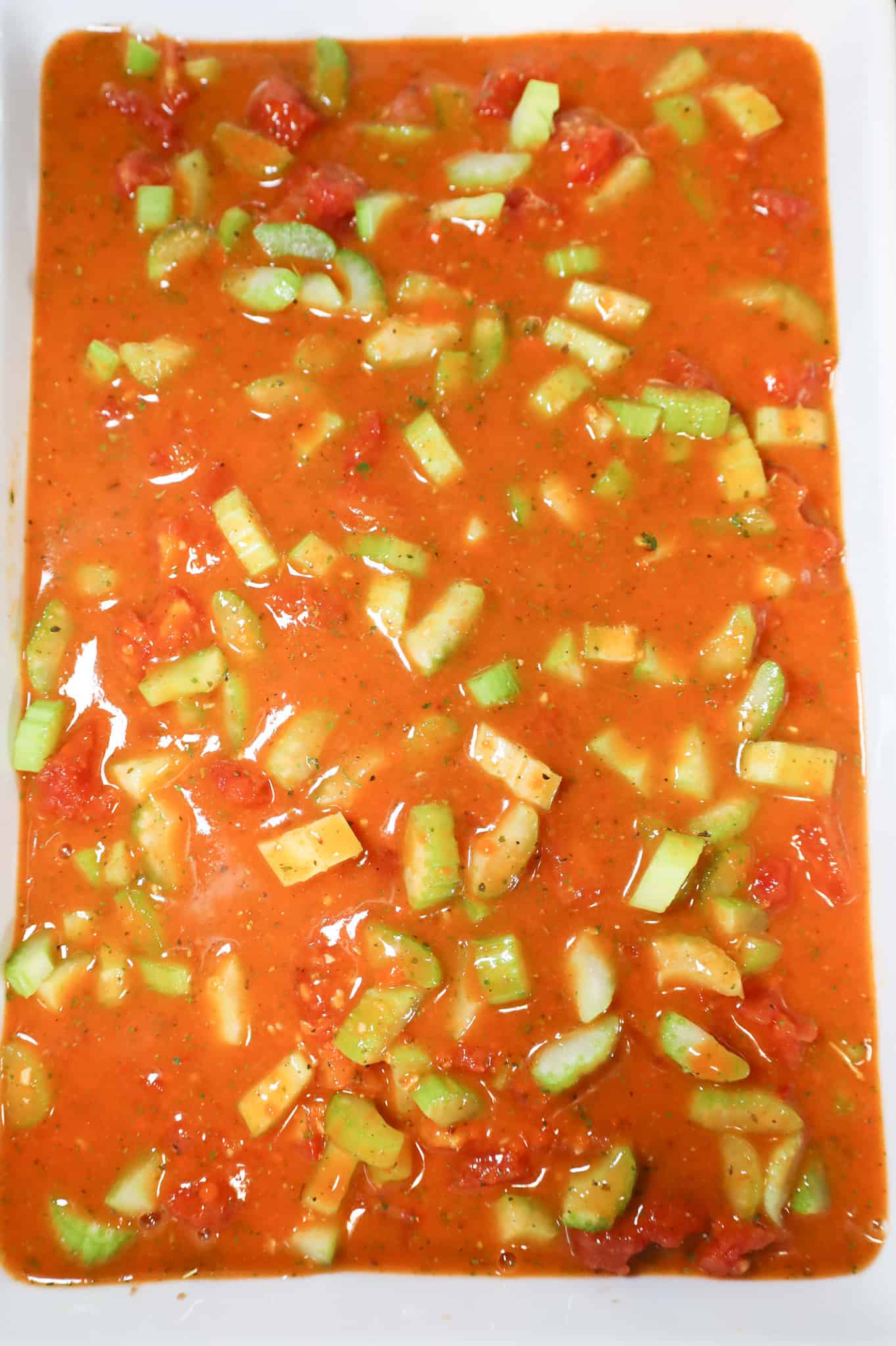 tomato soup mixture poured over ingredients in a casserole dish