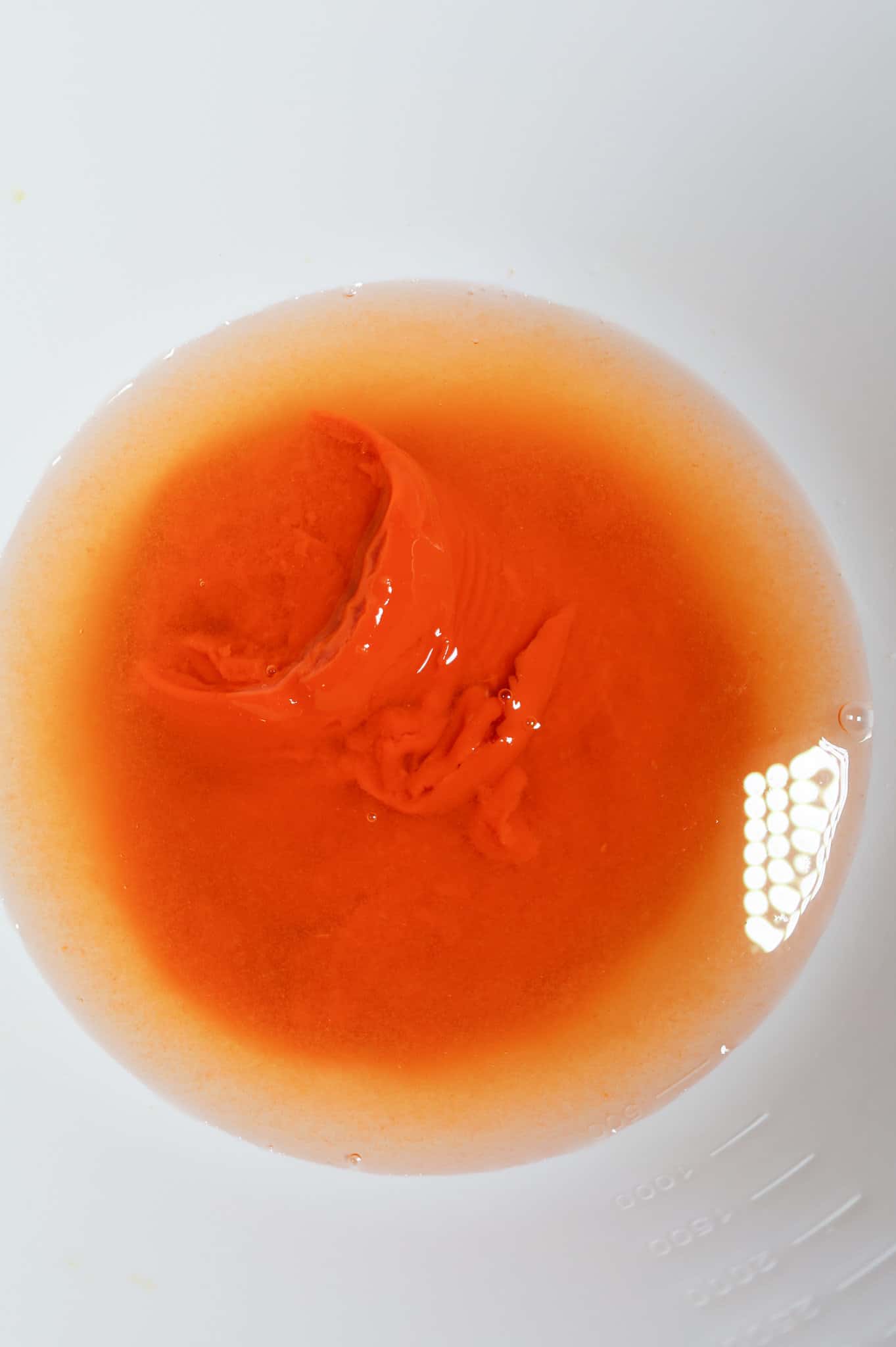 water and condensed tomato soup in a mixing bowl