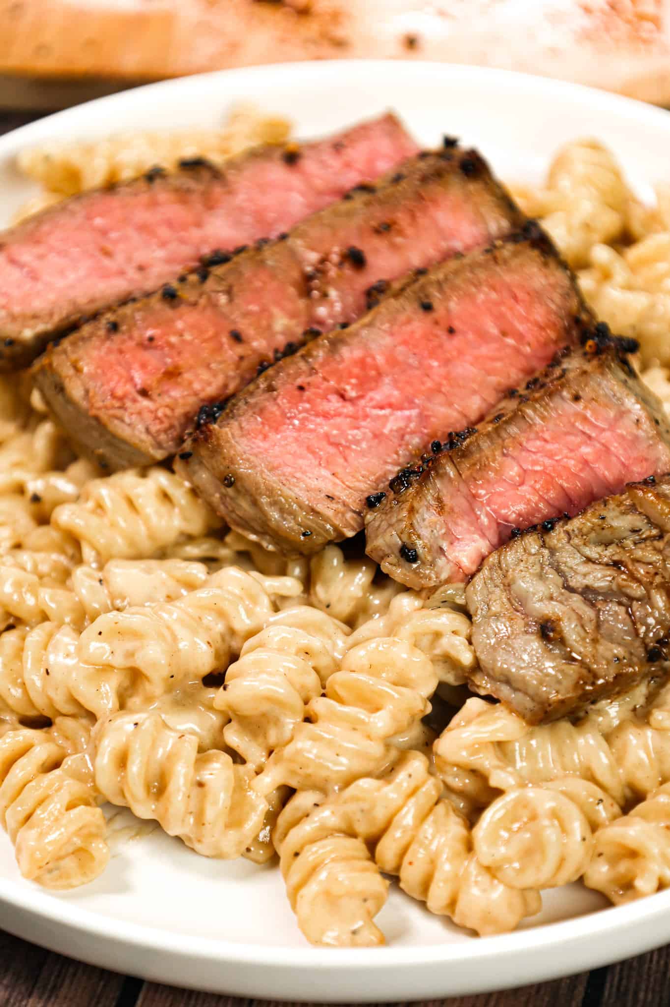 Steak Alfredo is an easy dinner recipe with creamy garlic parmesan pasta topped with tender slices of eye of round steak.