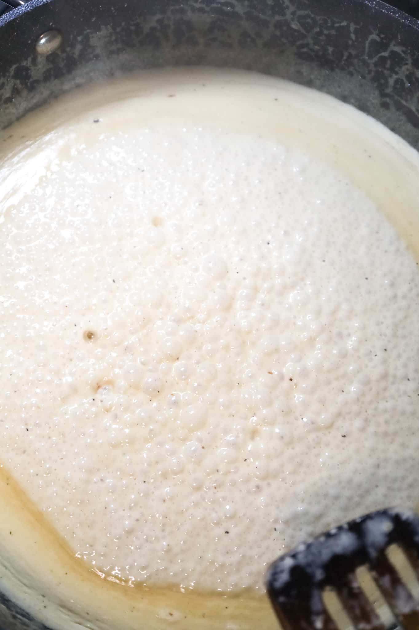 heavy cream boiling in a skillet