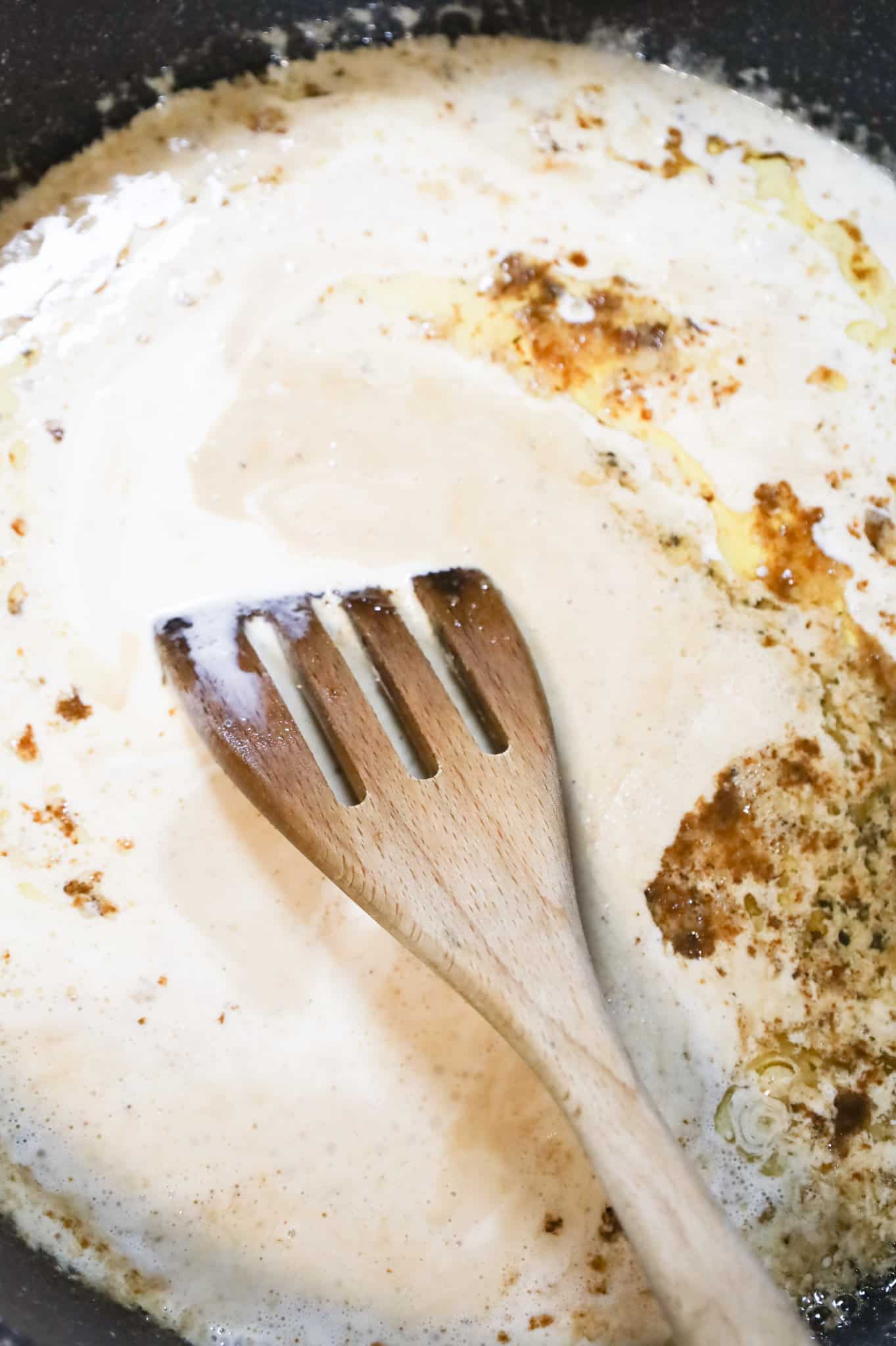 heavy cream added to a skillet with melted butter and garlic puree