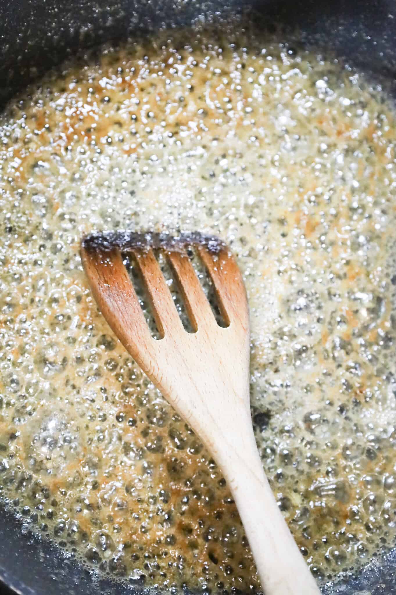 melted butter and garlic puree being stirred in a skillet