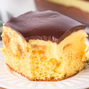 Boston Cream Poke Cake is a moist and delicious dessert recipe made with boxed yellow cake mix covered in creamy vanilla pudding and topped with chocolate ganache.