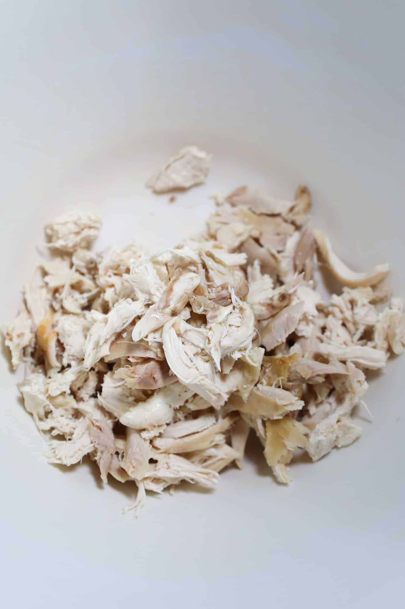 shredded rotisserie chicken in a mixing bowl